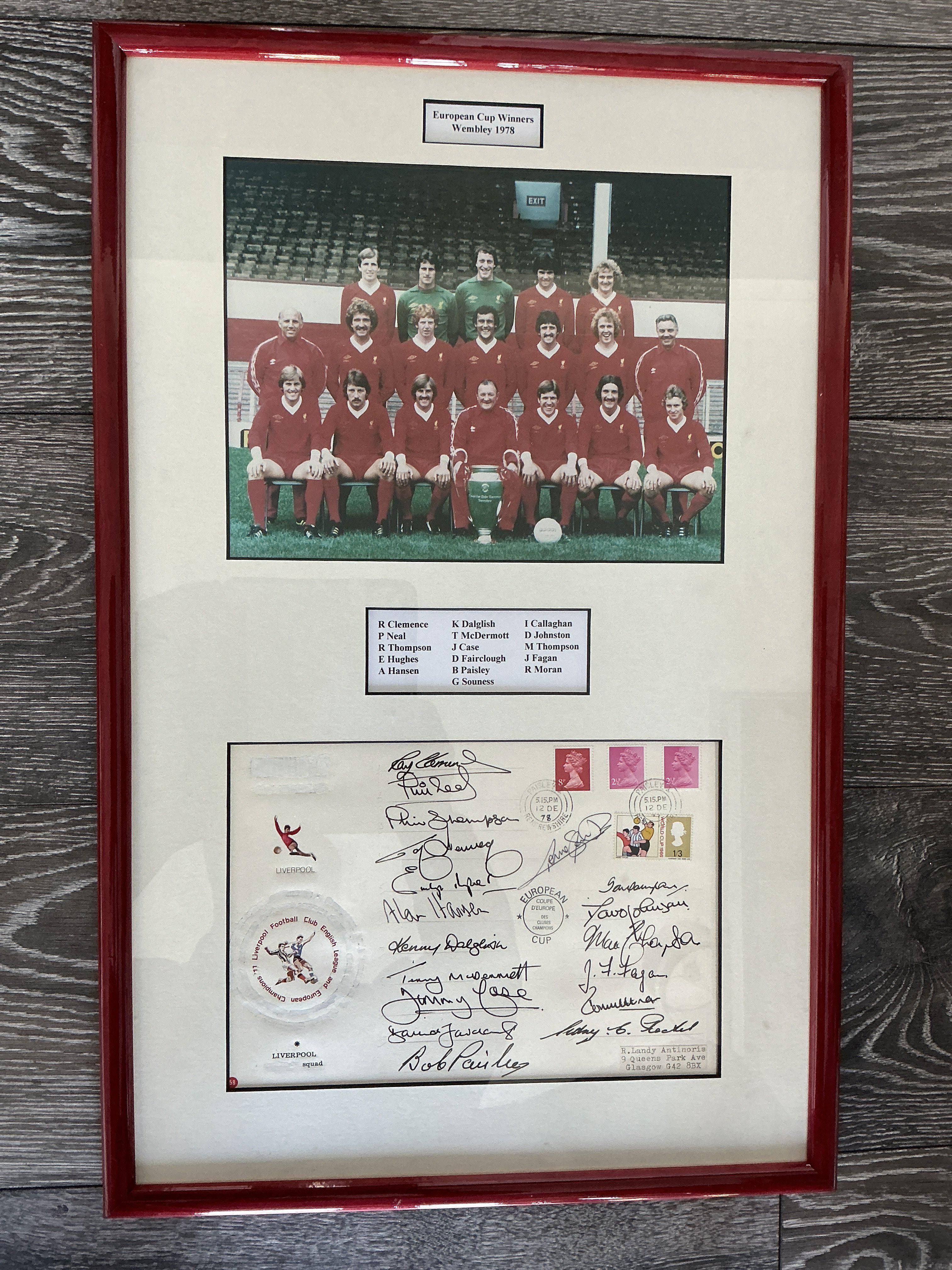 1978 Liverpool European Cup Winners Fully Signed Display: Below Liverpool team group with the European Cup is a large signed first day cover. Plaque names all the 16 that have signed. Full list is Clemence Neal Hughes Hansen Dalglish McDermott Case Fairclough Paisley Souness Callaghan Johnston Thompson Fagan and Moran. Beautifully framed in red with white boards.