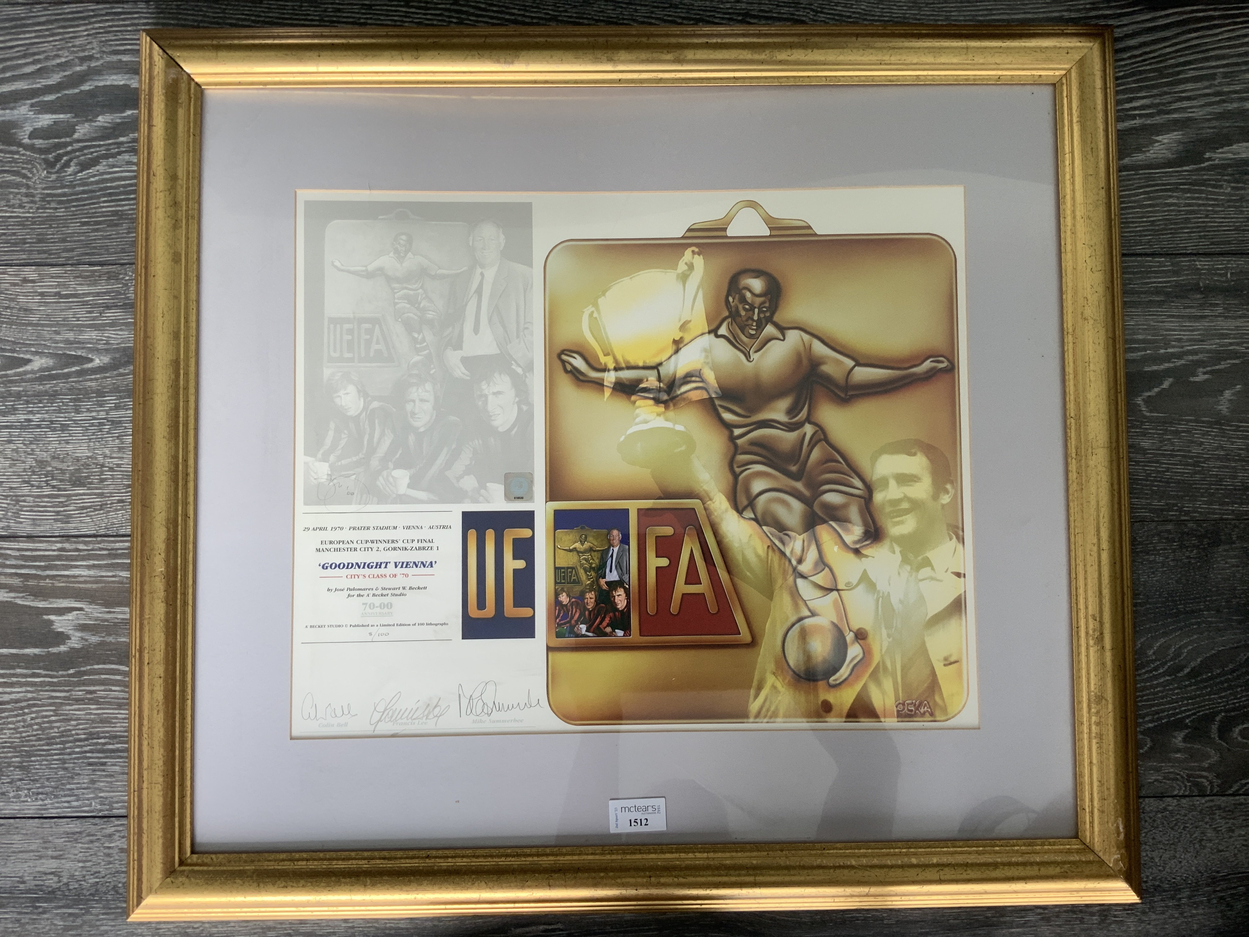 Manchester City 1970 ECWC Final Signed Football Print: Stunning limited edition print number 8/100 aptly named Goodnight Vienna with reference to Citys 1970 win in Austria over Gornik Zagreb. Print comes from reputable Becket Studio and is signed in pencil by Lee Summerbee and Bell. Tastefully framed in matching gold measuring 27 x 24 inches.