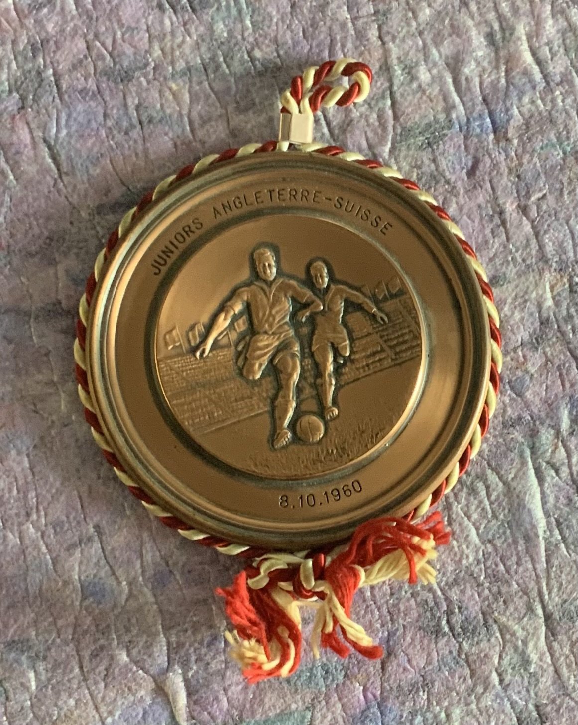 Ron Boyce 1960 England Youth Medal: Gold coloured medal which is engraved to front Juniors Angleterre - Suisse 8.10.1960. Boyce scored in the 4-3 victory over Switzerland in a youth match played at Brisbane Road. Medal is believed to be a gift to players from the Swiss FA. Excellent condition.