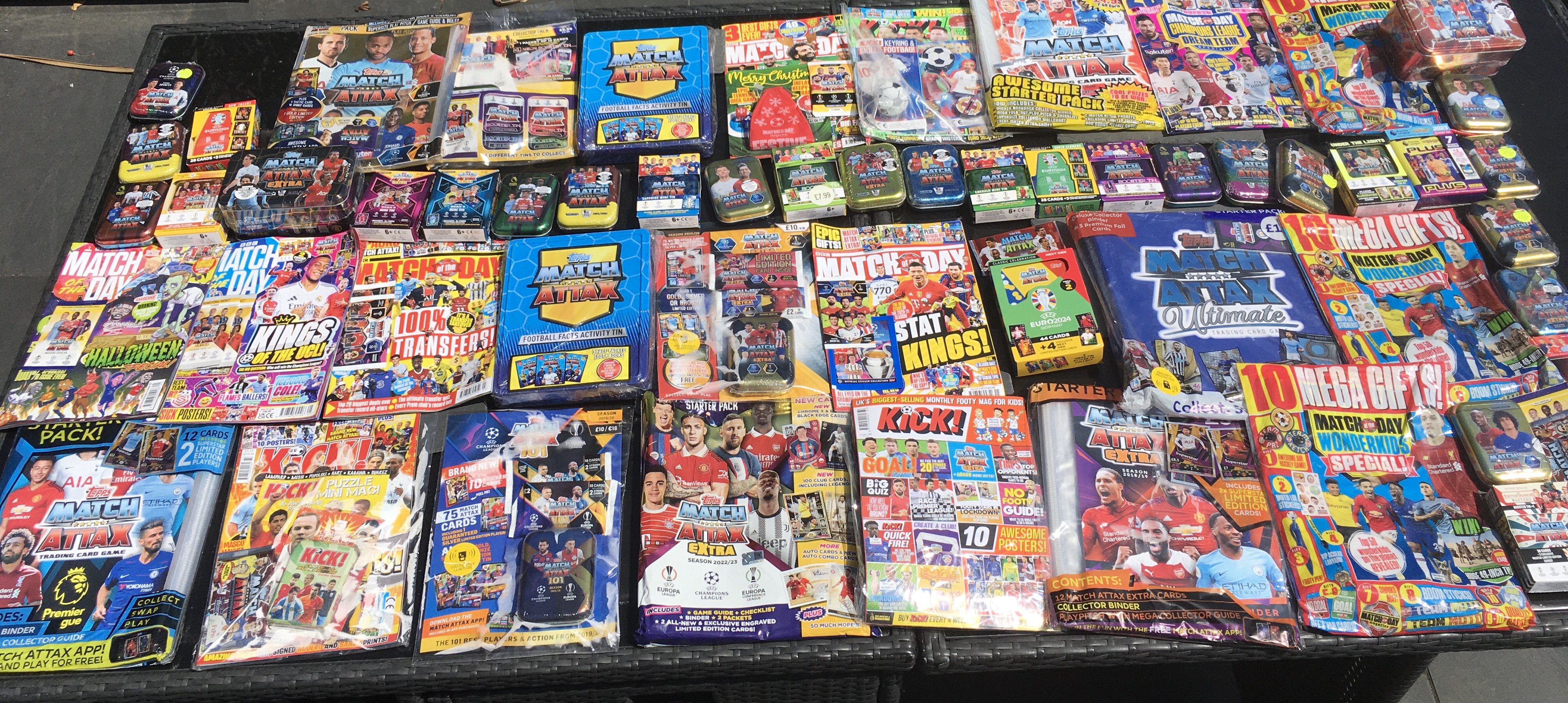Match Attax Sealed Football Card Collection: Around 40 sealed metal tins or sealed packs housed in cardboard from a modern era with a minimum of 7 pounds paid each per pack. Numerous magazines with free packs to encourage collecting plus some sealed empty albums and packs. Very large quantity which must have cost nearly 500 pounds when new.