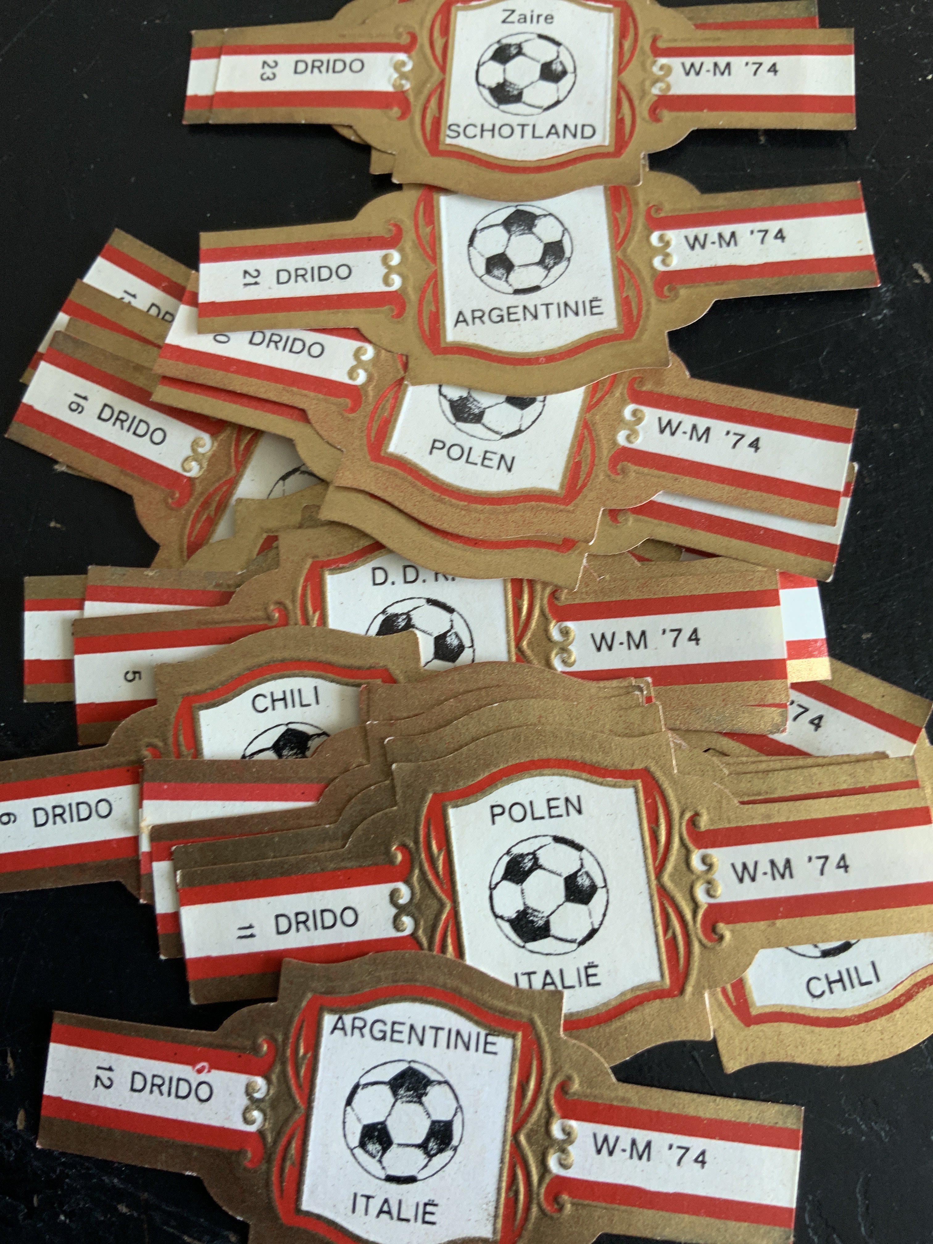 Football Cards + Memorabilia: 1974 Victor Calendar, 1966 World Cup Willie advert, Bob Wilsons incomplete Soccer Action album, Complete set of 24 1974 World Cup cigar bands and a further set with one missing.