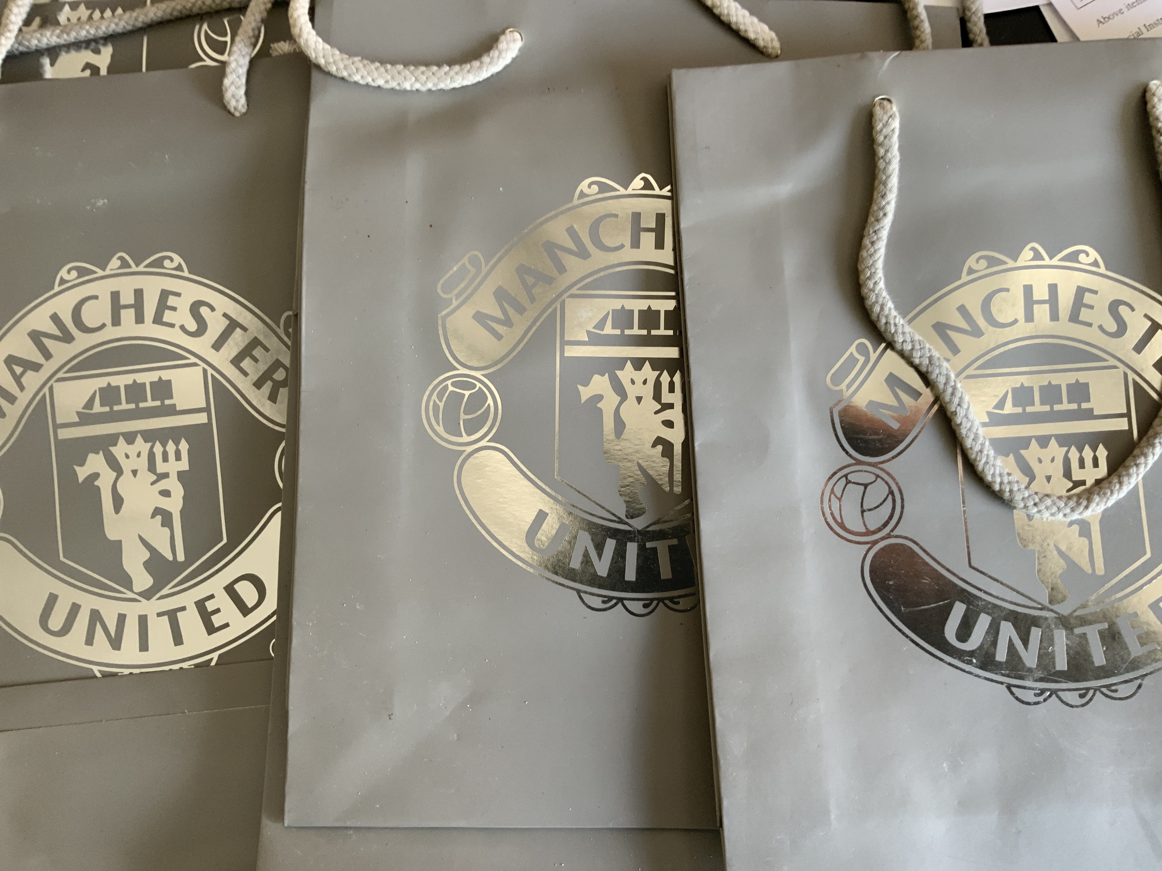 Manchester United Aquascutum Pens Corporate Football Gifts: 35 Aquascutum boxed pens in sleeve both stating Aquascutum. Pens were over from a corporate event at Manchester United and a Man Utd badge is embossed to pen. C/W 35 Man Utd gift bags. Please note on randomly testing 4 pens only one worked as these are from year 2000.