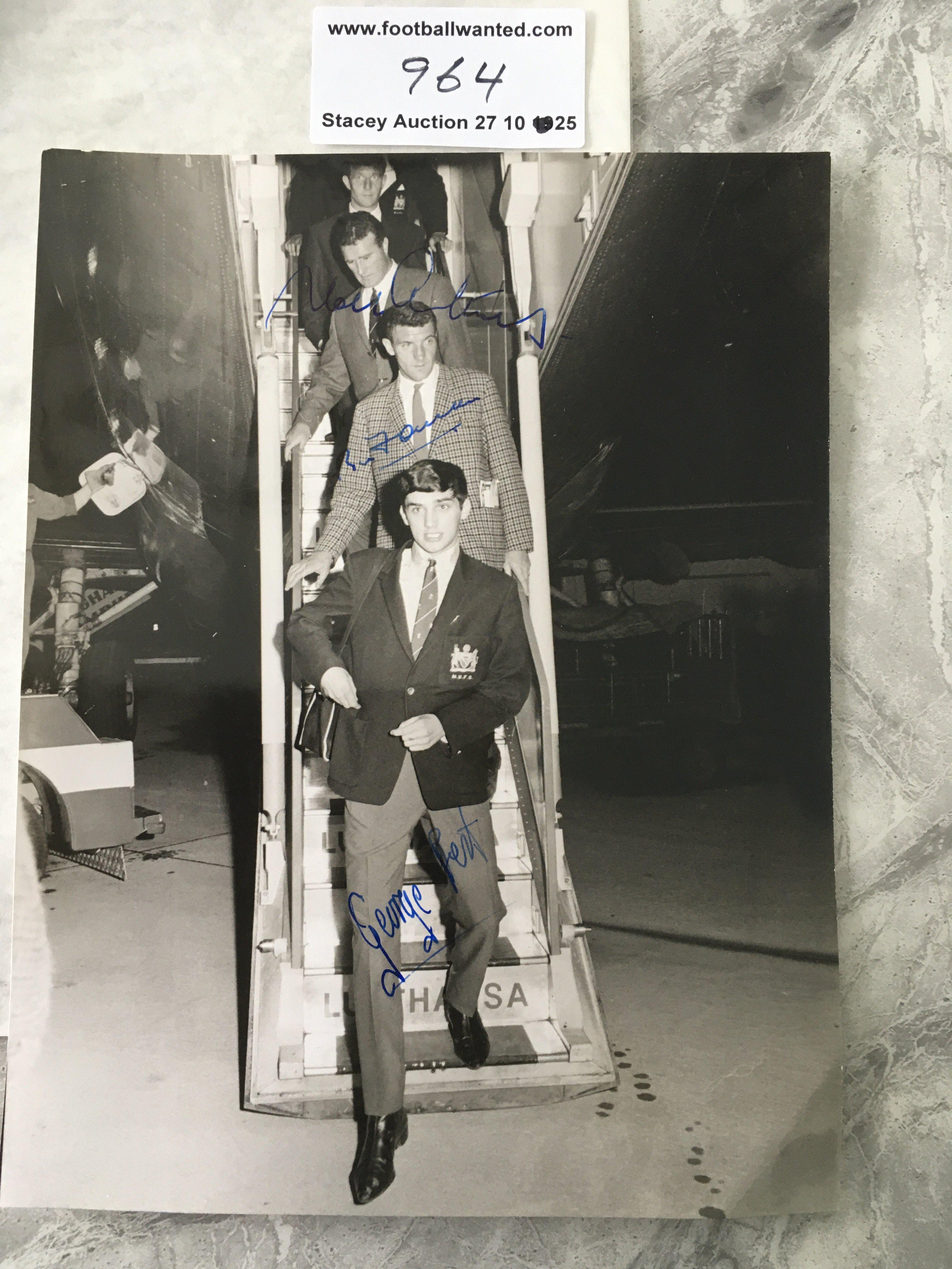 George Best Signed Manchester United Press Photo: Best Foulkes and Cantwell are coming down the stairs of the airplane in August 1964 in Hamburg. All 3 have clearly hand signed without dedication. Press stamp and German annotations to rear.