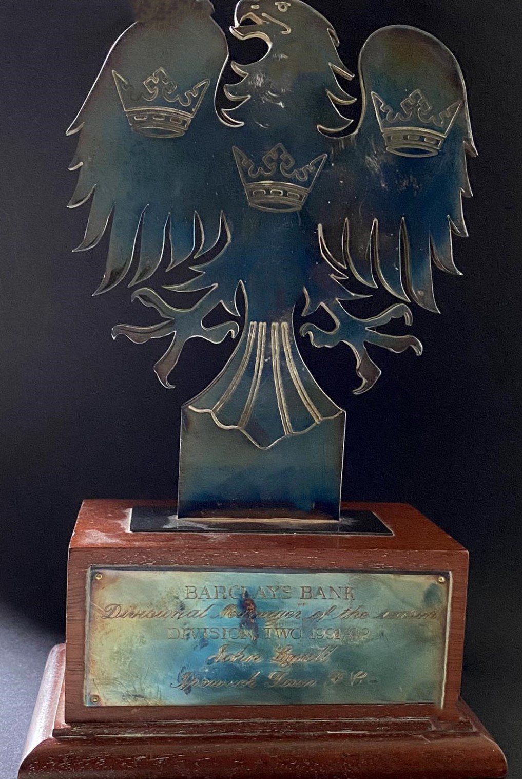 John Lyall 91/92 Ipswich Town Manager Of The Season Award: Wooden based trophy engraved to John Lyall. Photo of Lyall holding trophy when presented and another with other division winners both signed by Lyall. Ipswich tie included that he wore on the night he was presented this award.