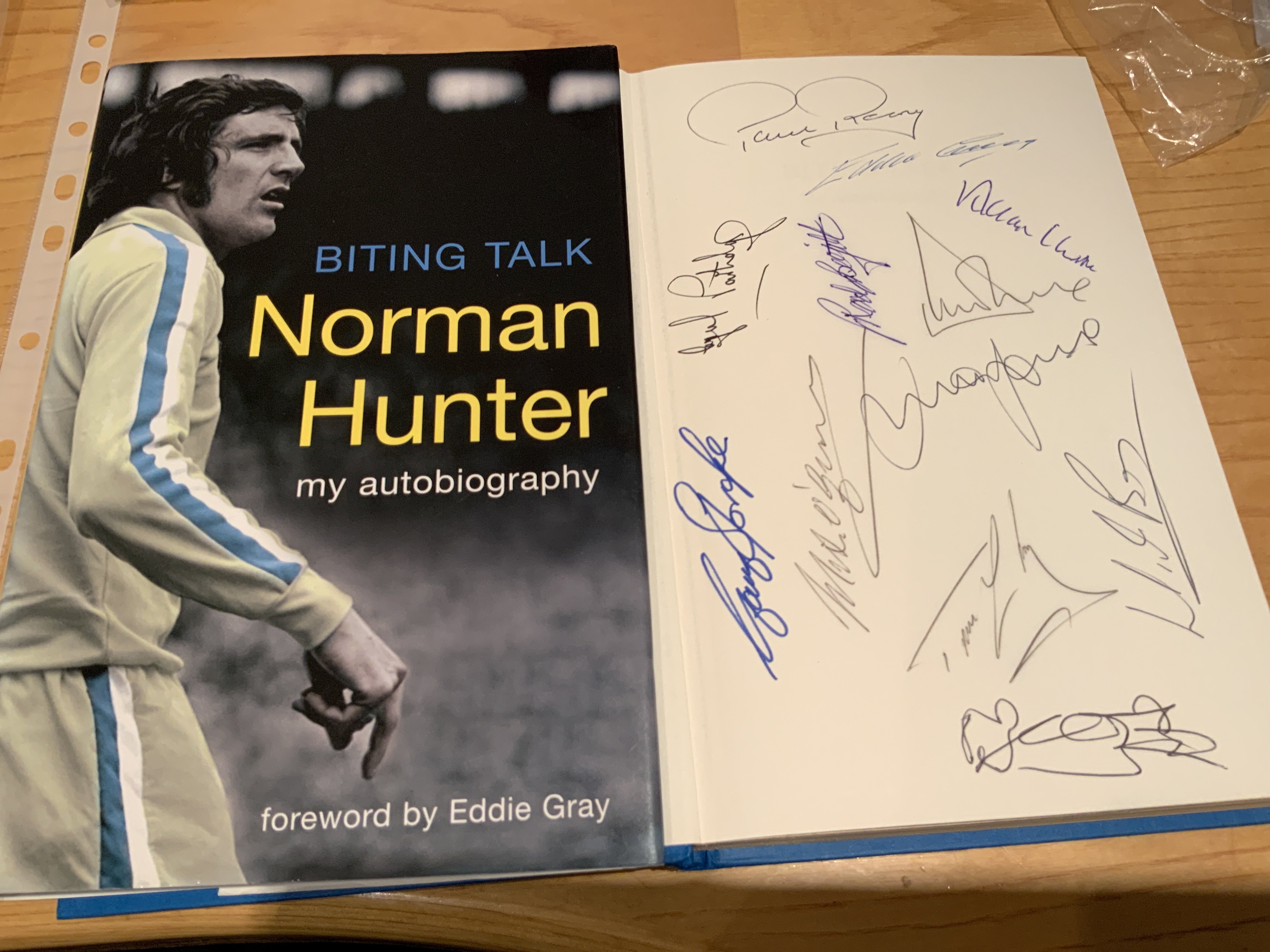 Norman Hunter Leeds United Multi Signed Football Book: Excellent hardback book with dust jacket signed on one page by Hunter and on inner page by 12 team mates including Clarke Reaney Jones and Sprake.