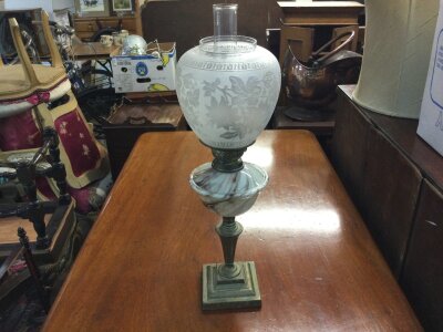 An oil lamp with bras base, a swirled marble effect glass font and an acid etched glass floral shade, 63cm tall