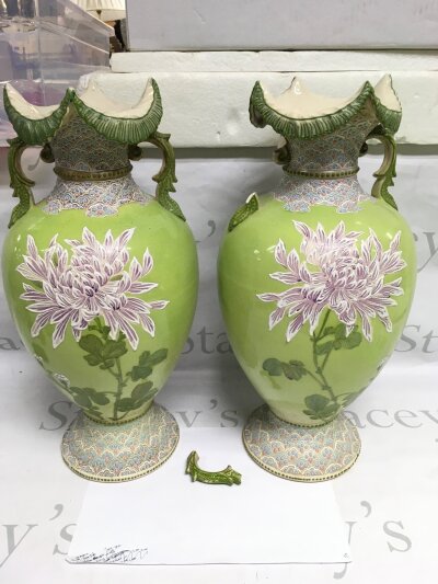 A pair of large late Victorian Japanese vases decorated with flowers on a green ground, one side scroll damaged. Approx height 46cm.