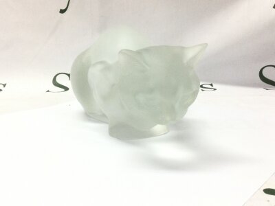 A Lalique cat sculpture. Small chip noted on ear. Approximately 26cm long.