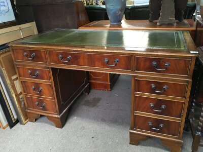 A Mahogany pedestal writing desk with a green leather insert. Dimensions 79cm tall, 136cm wide ,68cm long.