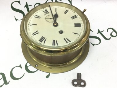 A brass ships clock with key. 21cm wide approx