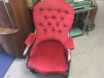 A Victorian open armchair with red upholstery.