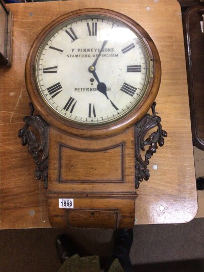A late Victorian wall clock with single fusee movement the case with applied carved oak leaf mouldings the dial with the inscription F Pinney & Sons Stamford Uppingham & Peterbough.