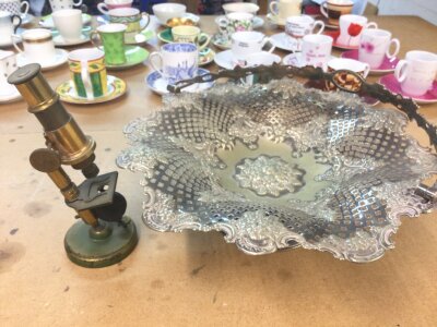 A silver plated basket (28cm wide) and a small microscope