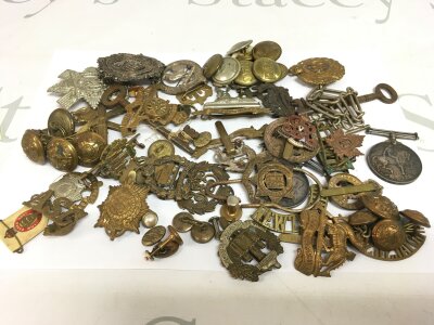 A WW1 medal and a collection of cap badges and tunic buttons. 97268 GNR E F CLEMENT.