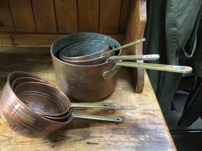 Three vintage copper pans and strainers.