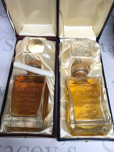 Two boxed cruise ship single malt whisky decanters, both sealed and full.