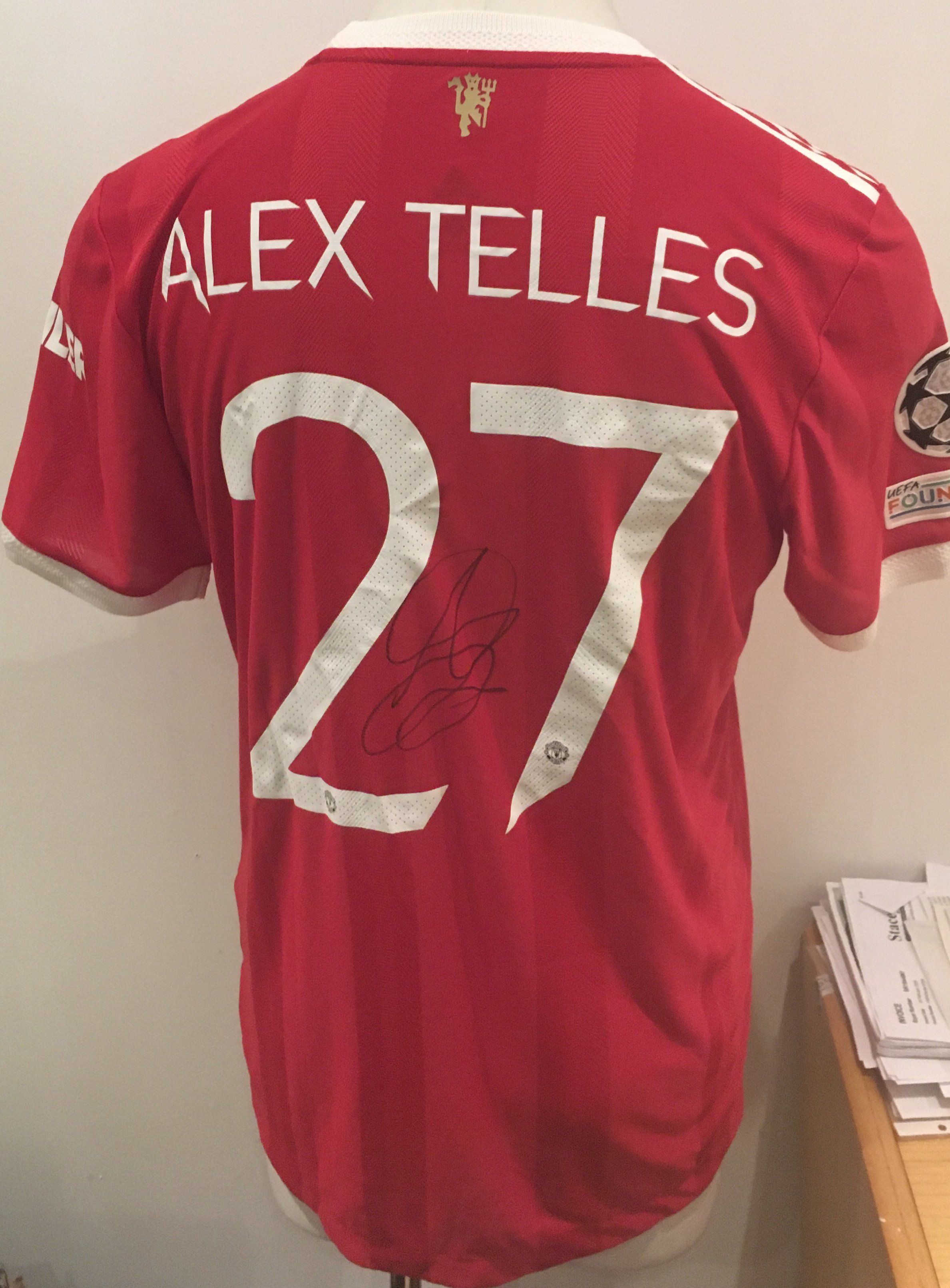 Telles 2021 - 2022 Manchester United Match Issued Football Shirt: Red short sleeve with Telles 27 to rear. UEFA Foundation badging. Signed to rear by Alex Telles and issued for match v Villarreal. Provided by Adidas during covid for player swaps. COA from reputable source.