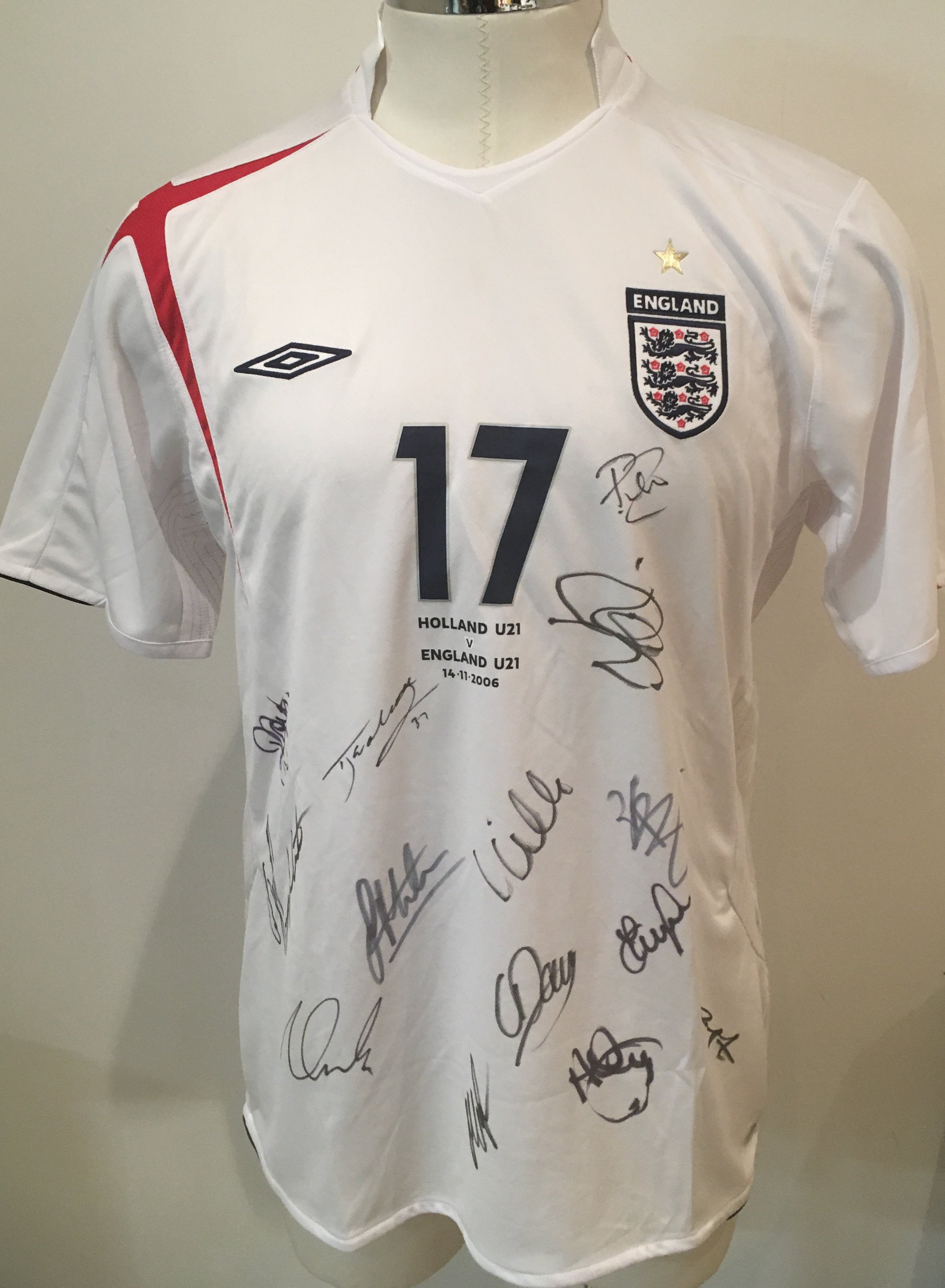2006 England U21 Signed Match Issued Football Shirt: England shirt signed by 14 players brought back by Peter Barnes the Tottenham + West Ham club secretary who travelled with the team. Number 17 with Holland U21 v England U21 14 11 2006 printed under number. Please note this was a spare and not used in match. England players in this match were Carson Hoyte Baines Davies Kilgallon Huddlestone Routledge Milner Whittingham Nugent Young Walcott and Jerome.