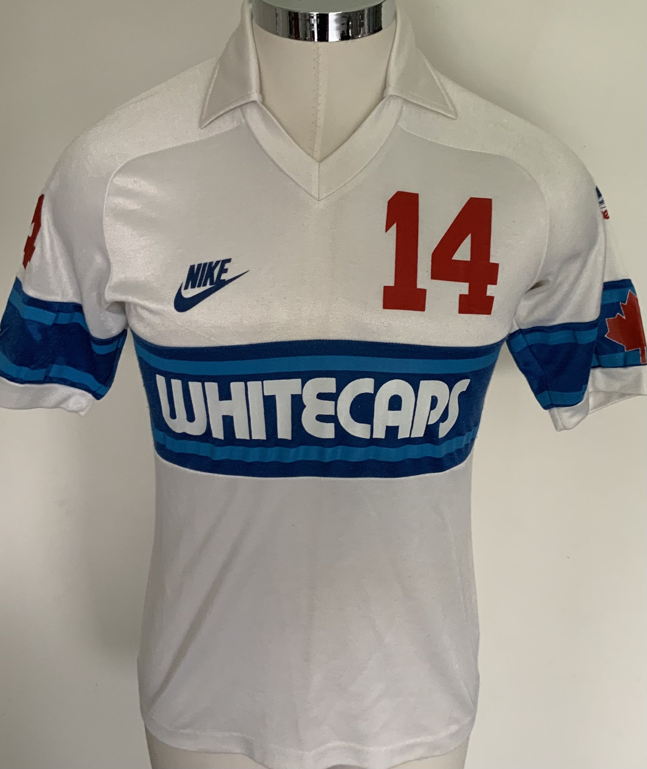 Vancouver Whitecaps 1983 Match Worn Football Shirt: Excellent condition very rare home shirt made by Nike. Number 14 to front rear and sleeves. Both sleeves have the Canadian flag and one had an advert for Super Bowl 83 in Vancouver. Medium size attractive shirt has Taylor to rear