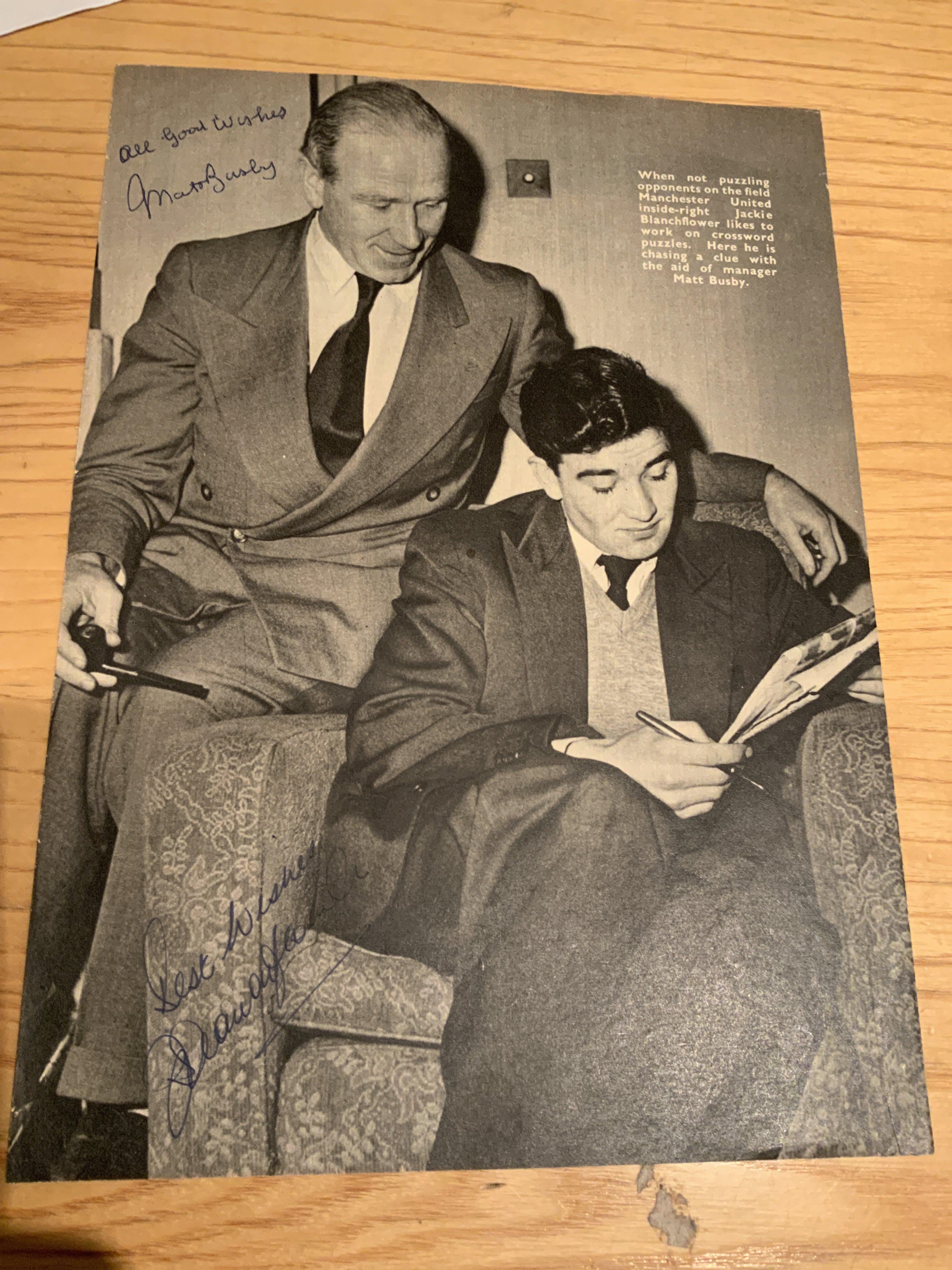 Matt Busby Signed Manchester United Football Picture: Full size black and white magazine picture depicting Busby helping Jackie Blanchflower with his crossword. Signed clearly without dedication by both.