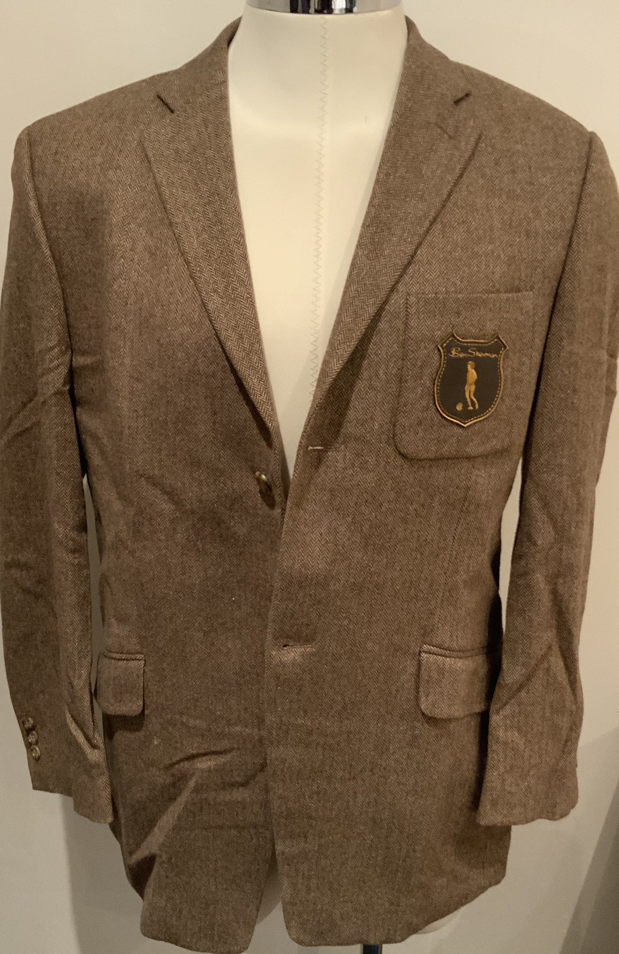 George Best Boutique Blazer: Stunning brand new condition brown herring bone style blazer with leather affect breast having George Best silhouette under the word Ben Sherman. Lined with image of Best and label stating George Best Ben Sherman Limited Edition. Could be worn today.