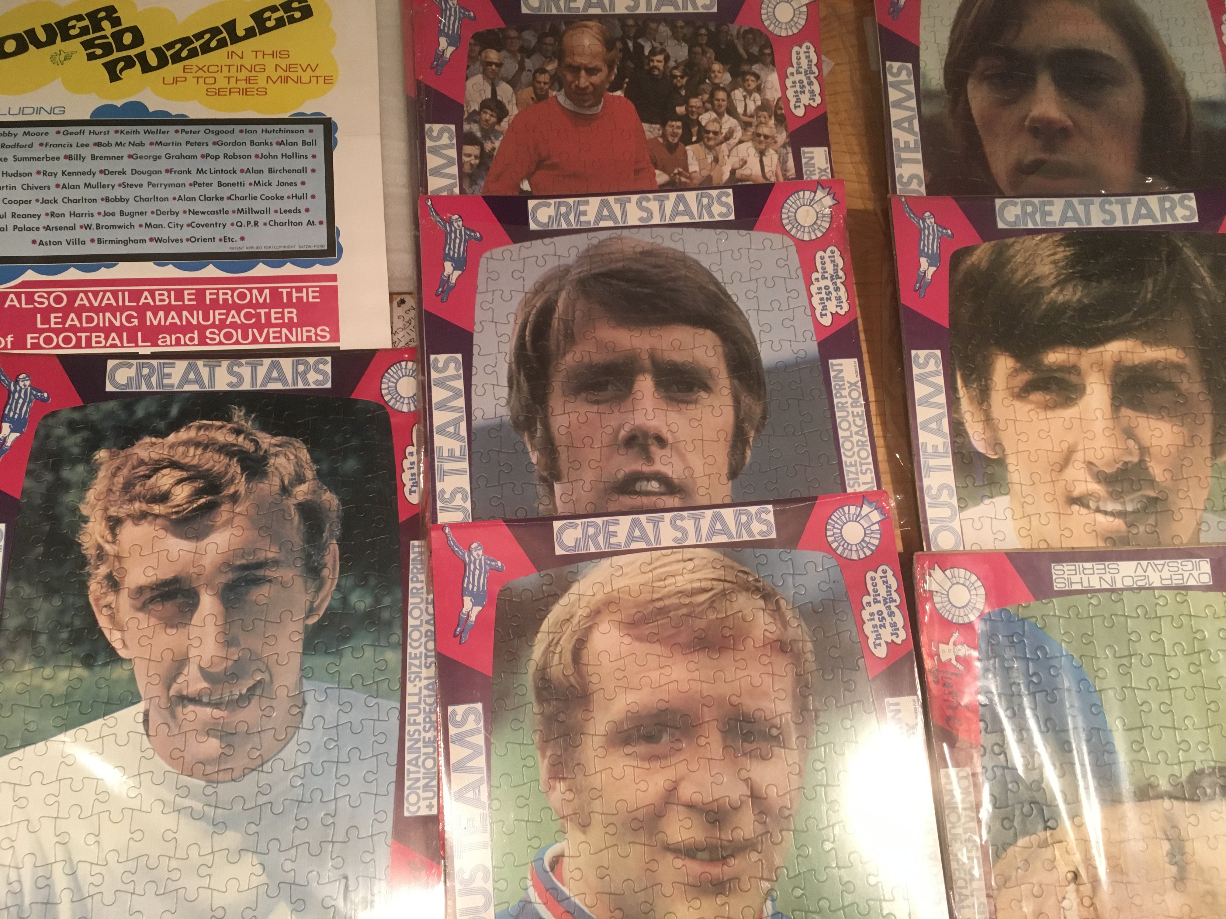 1970 Football Players Original Unused Jigsaw Puzzles: Individual players including Hurst B Charlton George Lee and Webb. Jigsaws are still in cellophane and measure 12 x 17 inches. C/W advertising poster for them. Slight duplication. (11)
