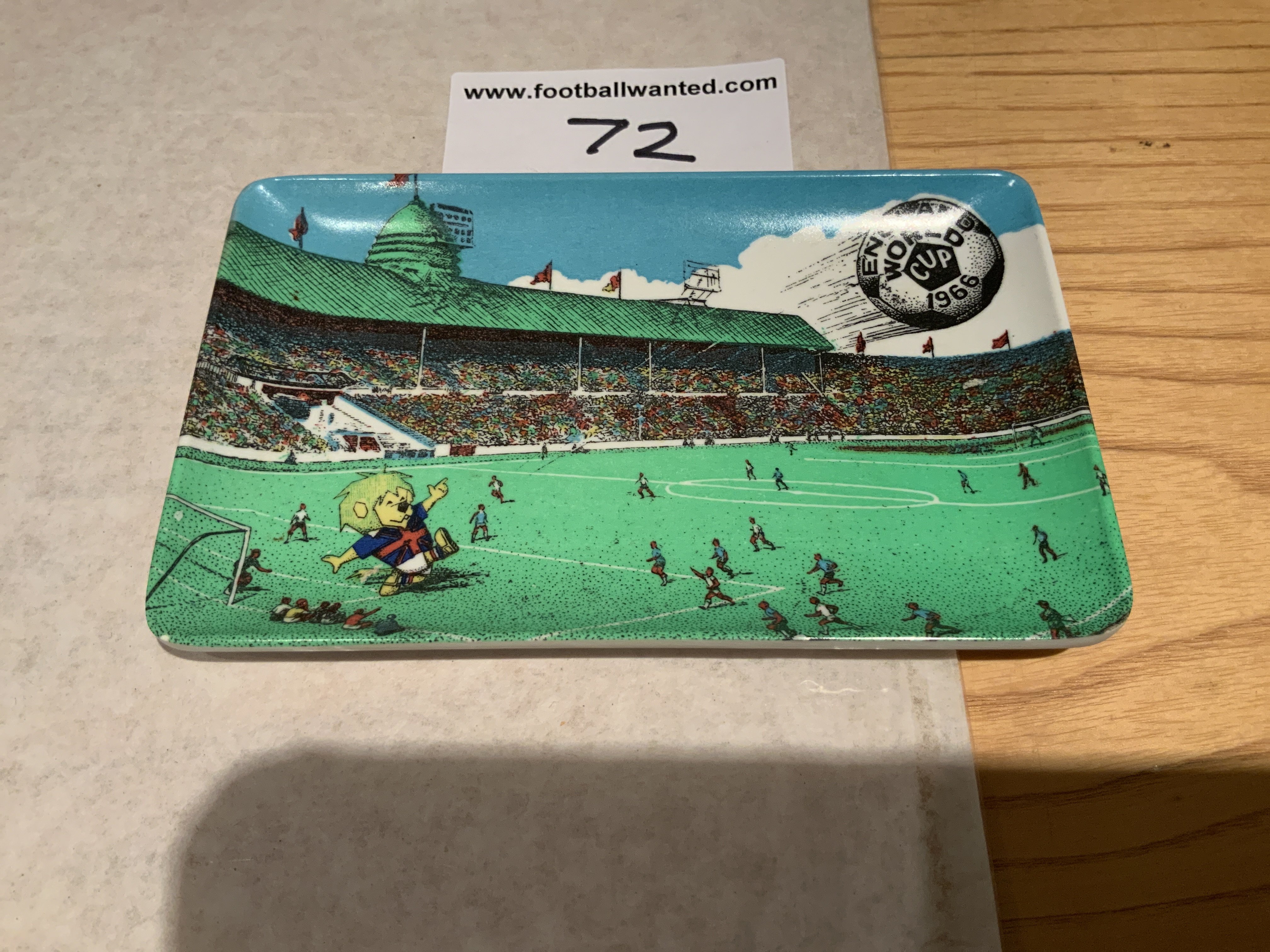 1966 World Cup Willie Football Ash Tray: Small plastic ash tray or soap dish measuring 5 x 3 inches. Depicts World Cup Willie at Wembley Stadium during a match with an England World Cup 1966 on ball that WC Willie has just kicked. Rear states a Cotswold Product.