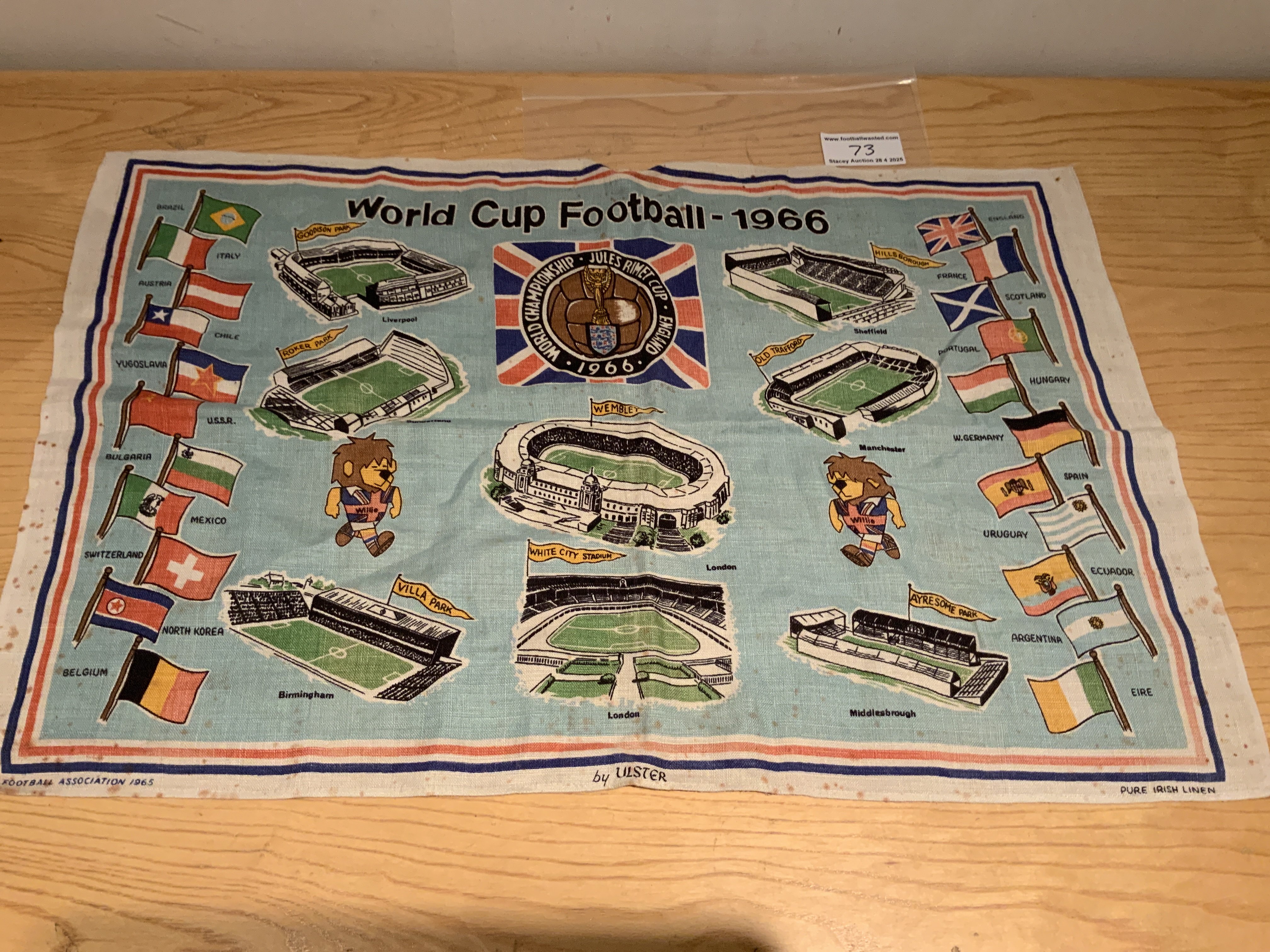 1966 World Cup Willie Football Tea Towel: Depicts flags of the 16 participating nations, pictures of all 8 venues, the World Cup 66 logo and of course WC Willie. Original pure Irish linen measuring 30 x 19 inches. Football Association copyright 1965 to corner. Good condition with a few age spots.