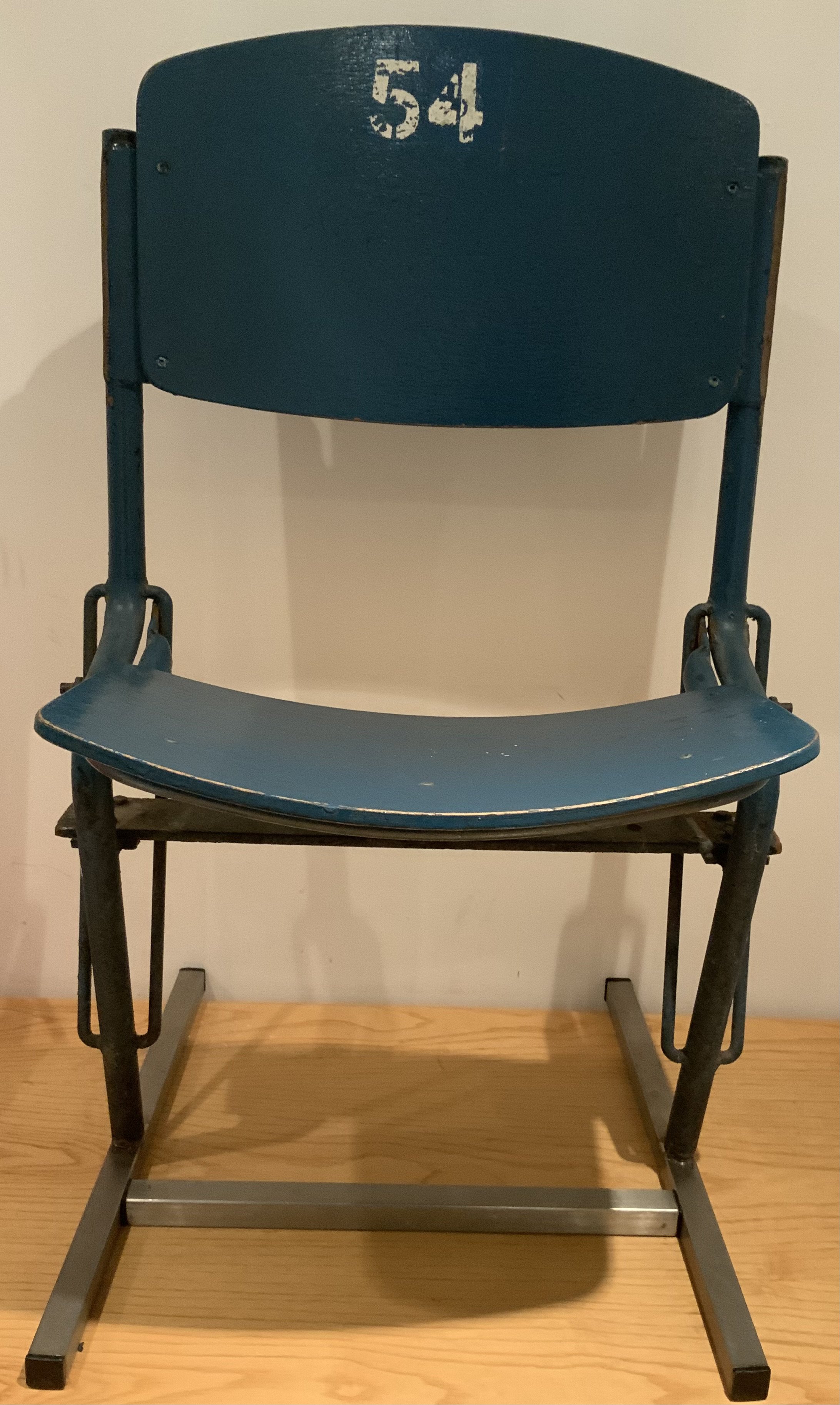 Old Wembley Football Stadium Original Seat: Not many whole seats made it out of the old Wembley after its closure in 2001. There was a contract for some seat backs to be removed though. This is the whole seat cut where it entered concrete. A stand has been made for it to slot into so its fully useable in a man cave or museum. Blue seat still has number 54 and has original blue paint.