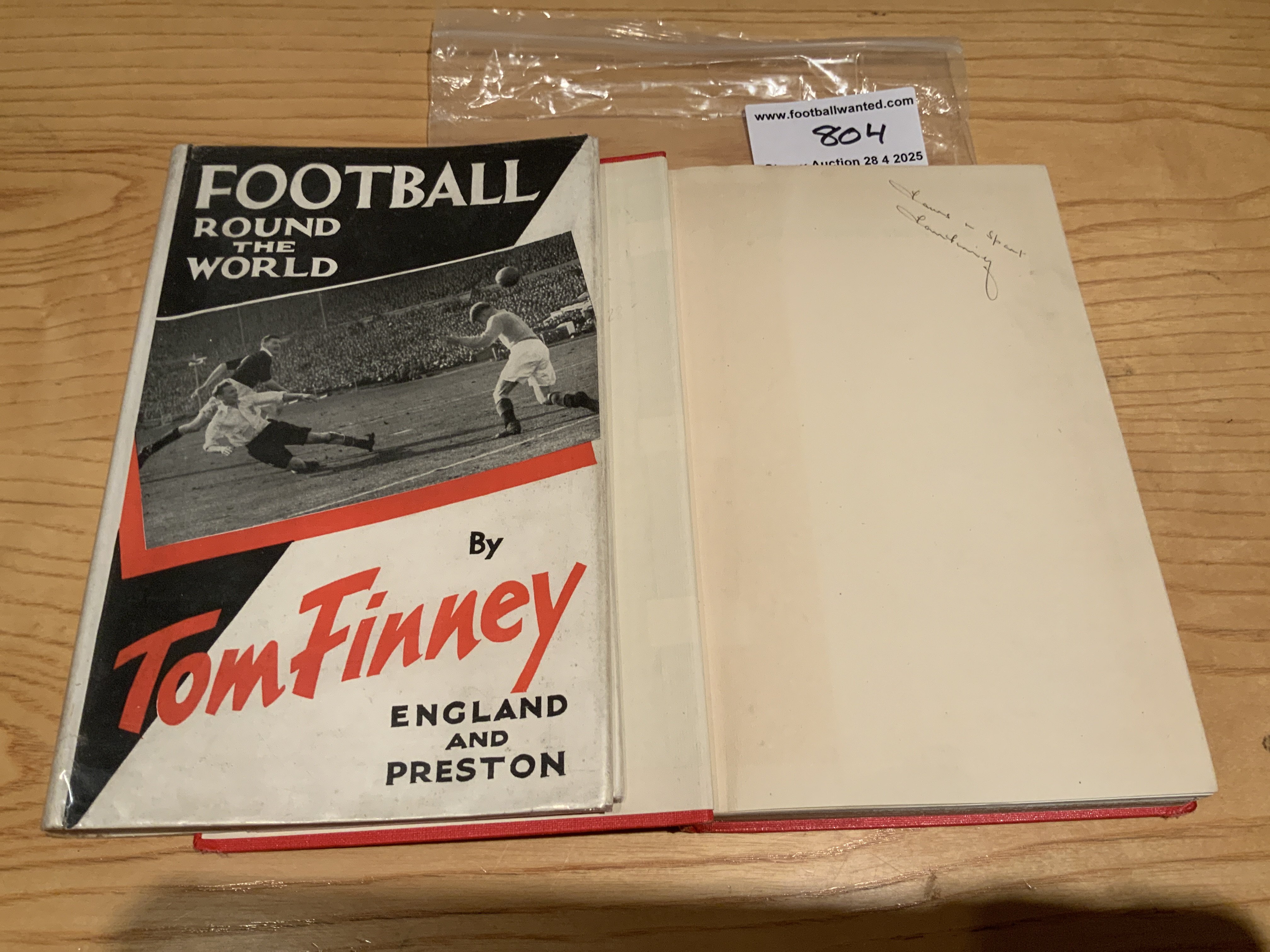 Tom Finney Signed Football Book: Football Round The World hand signed without dedication by the Preston and England star. Very good condition hardback book and dust jacket.