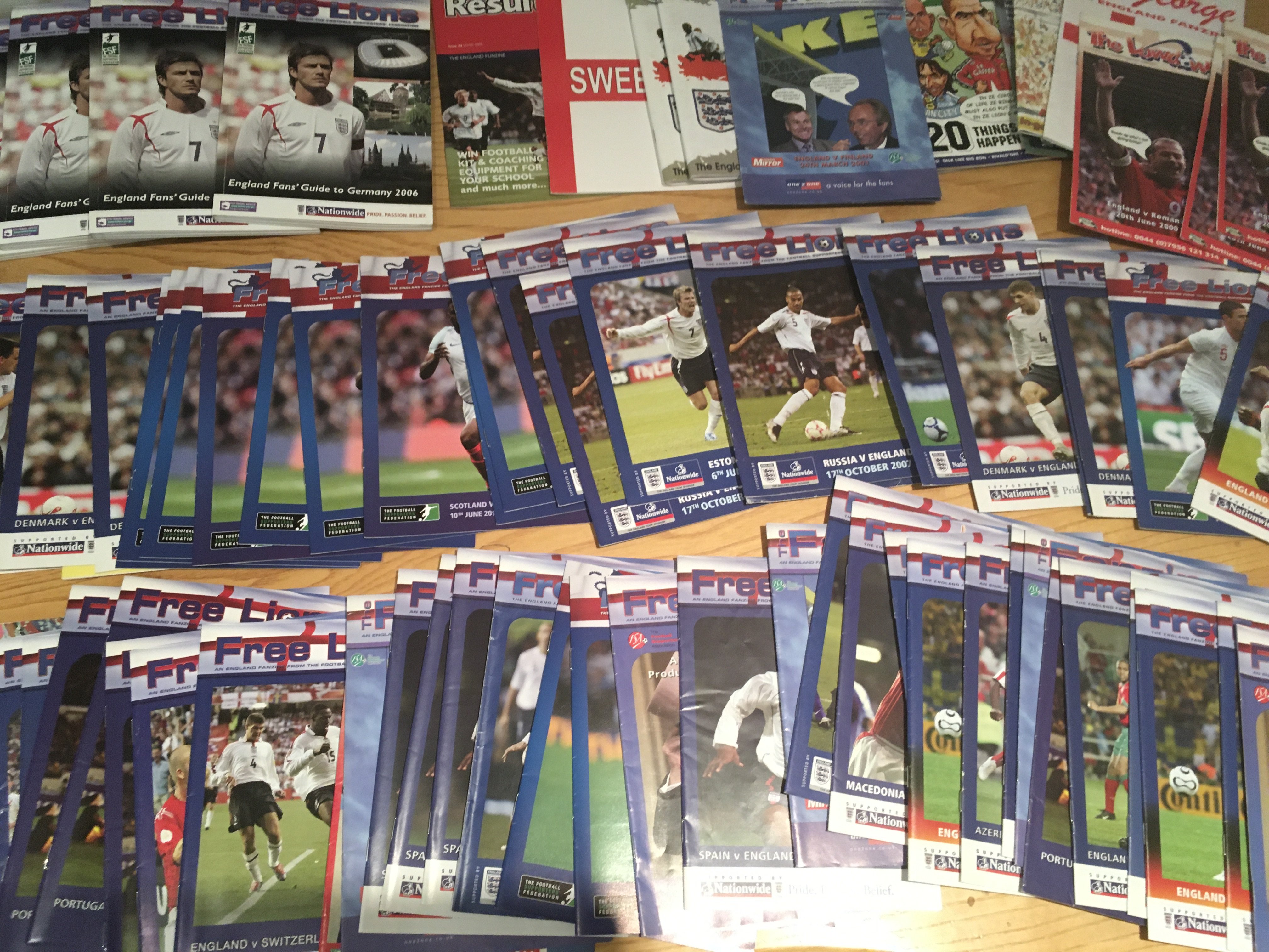 England Football Team Magazines + Fanzines: From the Millennium up to more modern to include Free Lions, St George, Lowdown, Funzine, Score and OLAS, Sweet FA and Result. Mostly Free Lions to include 4 x 2006 FA Guide To Germany. Excellent with instructions to sell. (75)