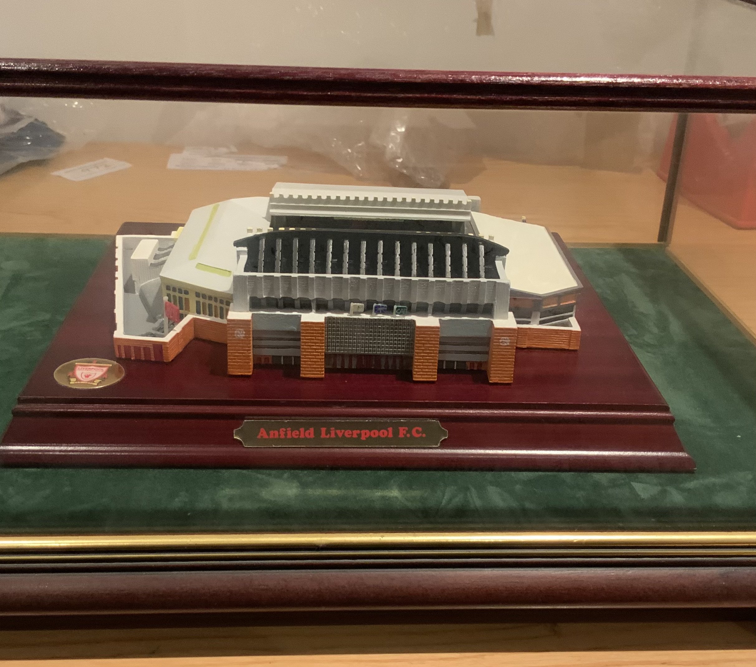 Liverpool Anfield Football Stadium Model: Lovely detailed stadium model in glass case measuring 16 x 13 and about 7 inches high. C/W certificate and two pieces of rock from the old Spion Kop end. C/W hand signed card with autographs to include Houghton Rush and Grobbelaar.
