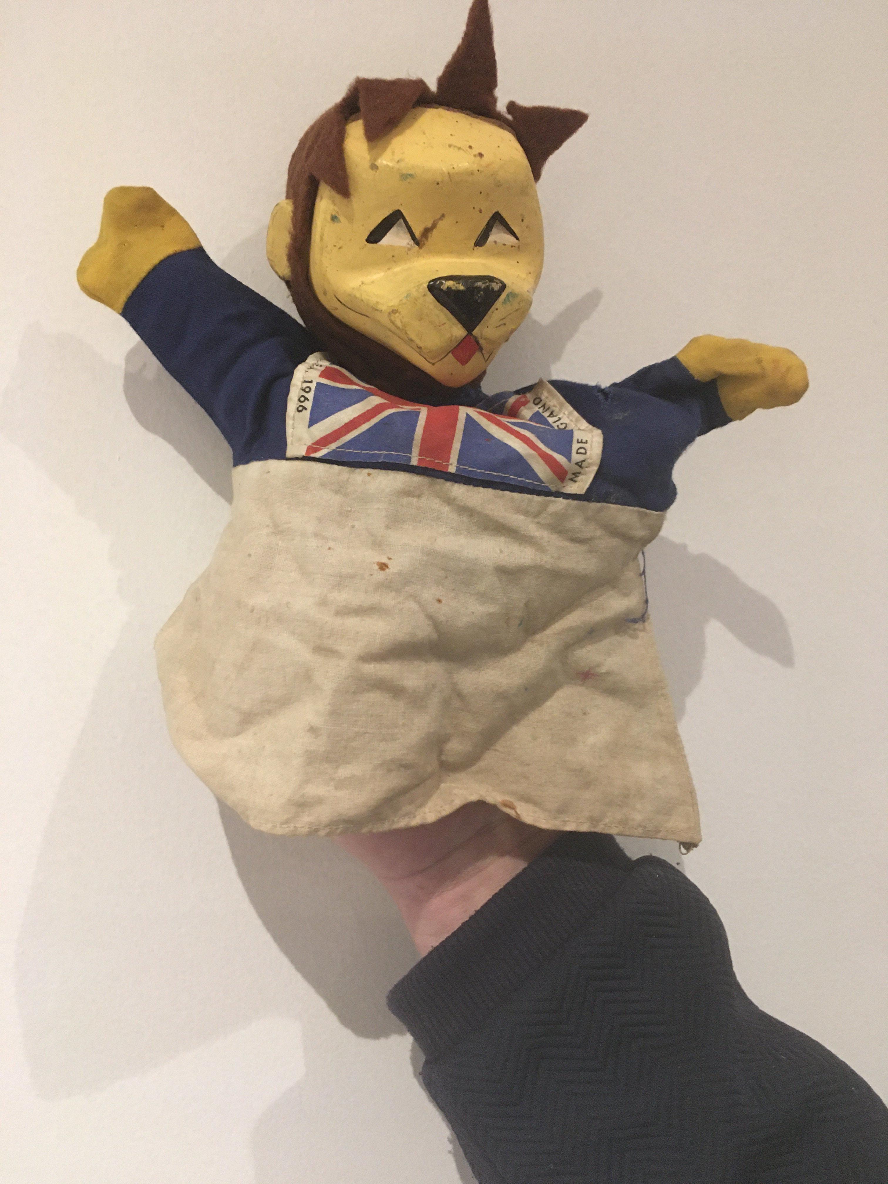 1966 World Cup Willie Rare Football Puppet: Possibly one of the rarest WC Willie items. Hand puppet featuring an England flag to his chest with copyright FA 1966 Made in England to edges. Wear and small hole to cloth.