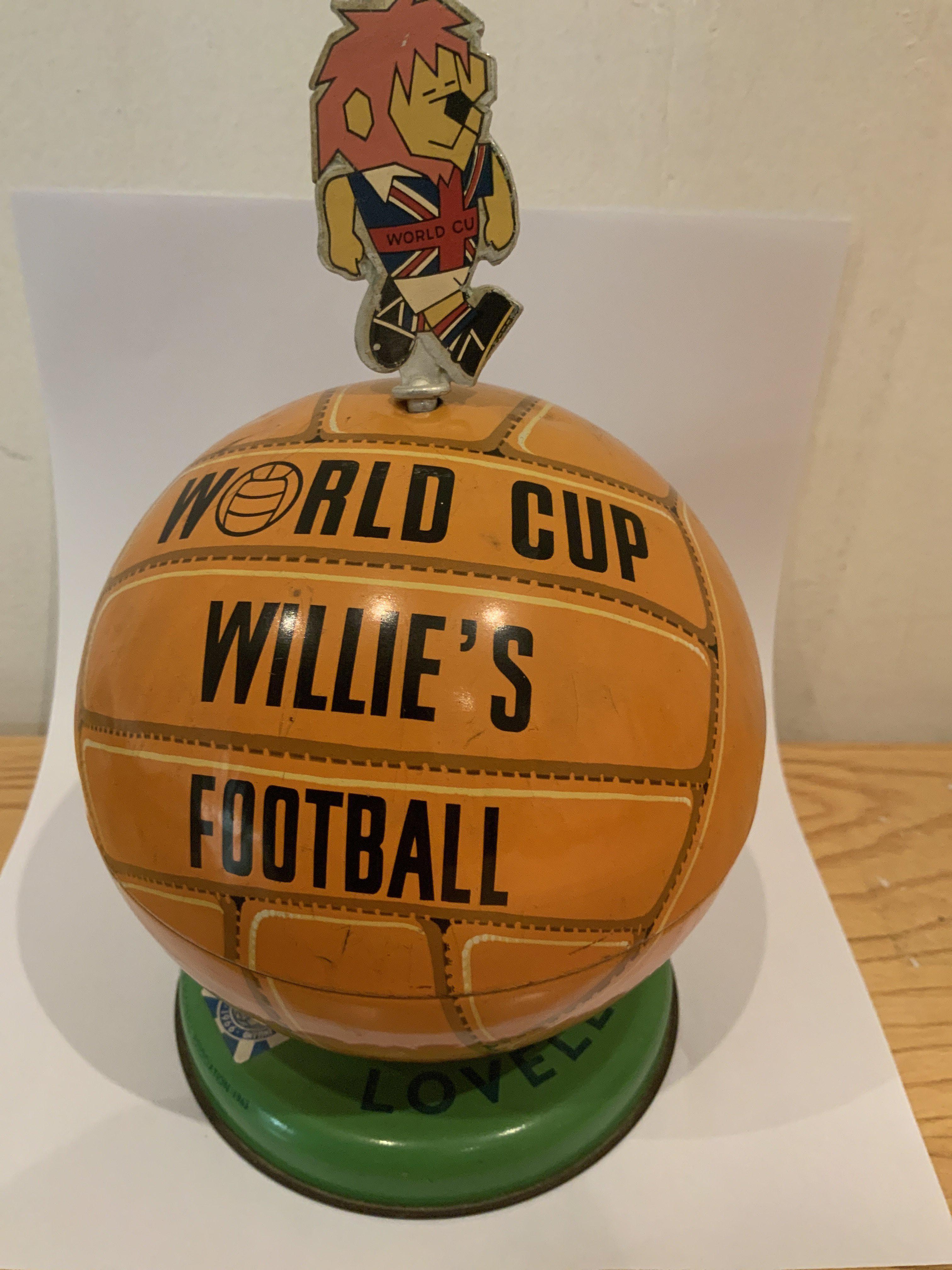 1966 Football World Cup Willie Toffee Tin: Lovells football shaped metal tin with FA 1965 to base. Top which lifts off states World Cup Willies Football. WC Willie is never intact as kids used him to pull lid open but he is present and can be stuck back.