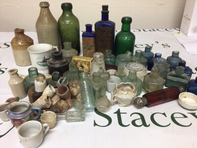 A Collection of 19th century glass ink bottles. A cranberry glass scent bottle with silver ends other glass bottles and clay pipe fragments.