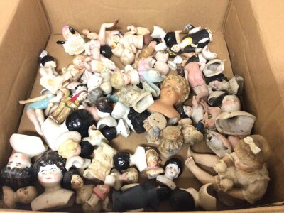 A box containing a large quantity of pin dolls miniature bisque dolls dolls heads and other conforming figures.