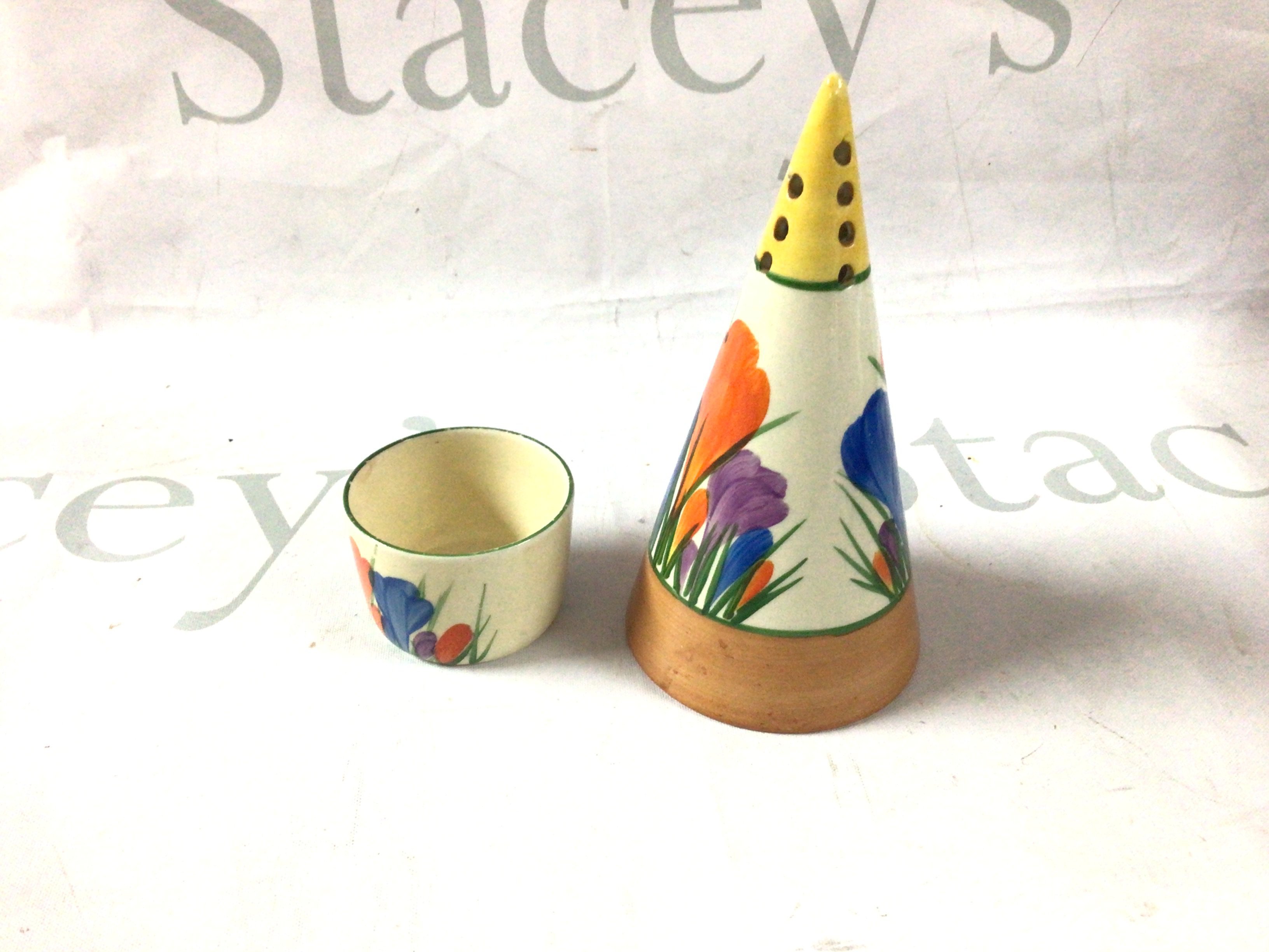 A Clarice Cliff egg cup and shaker.