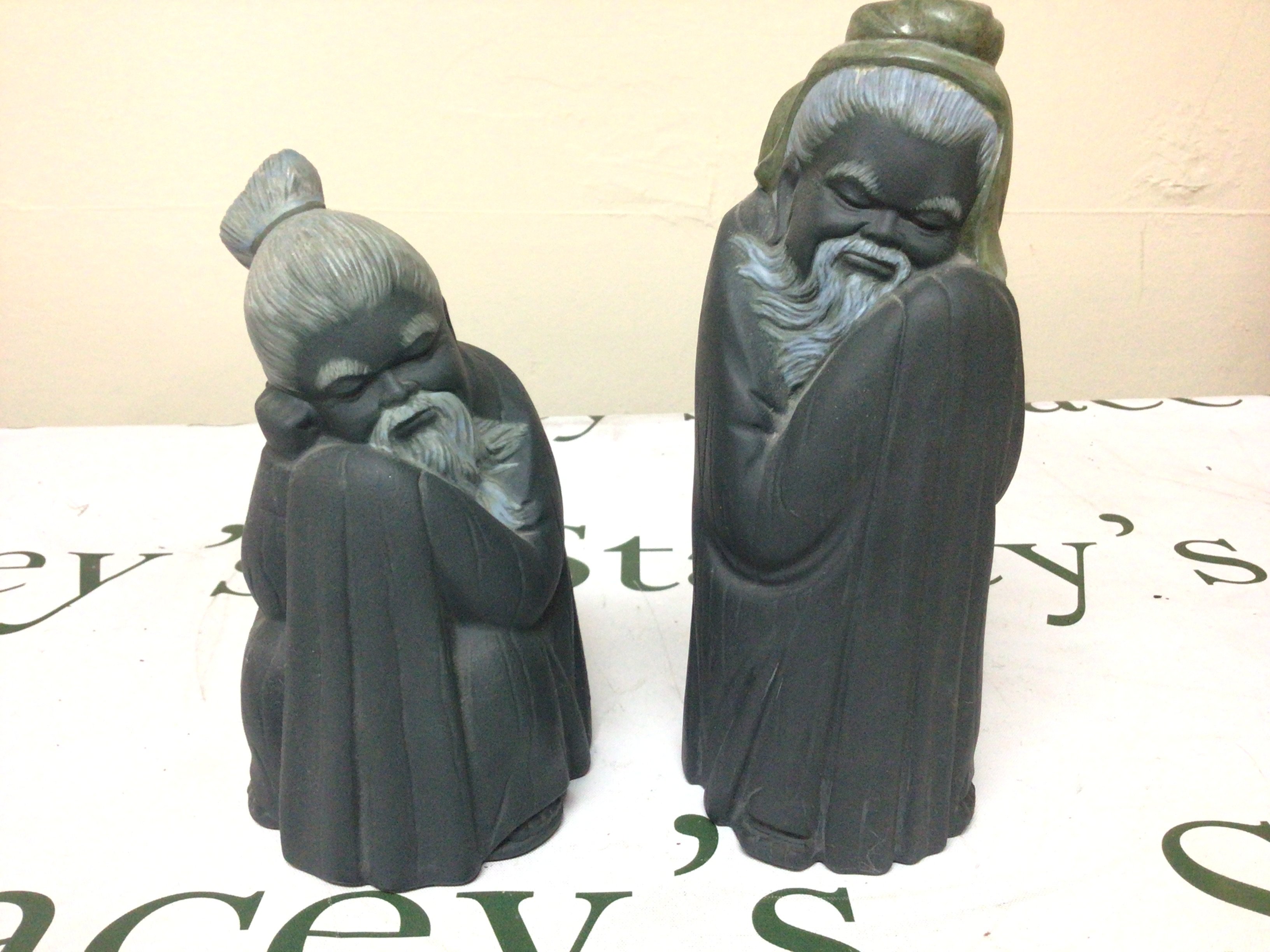 Two Lladro figures of Chinese elders at rest with a blue slate finish Matt glaze. Height 20cm no obvious damage.