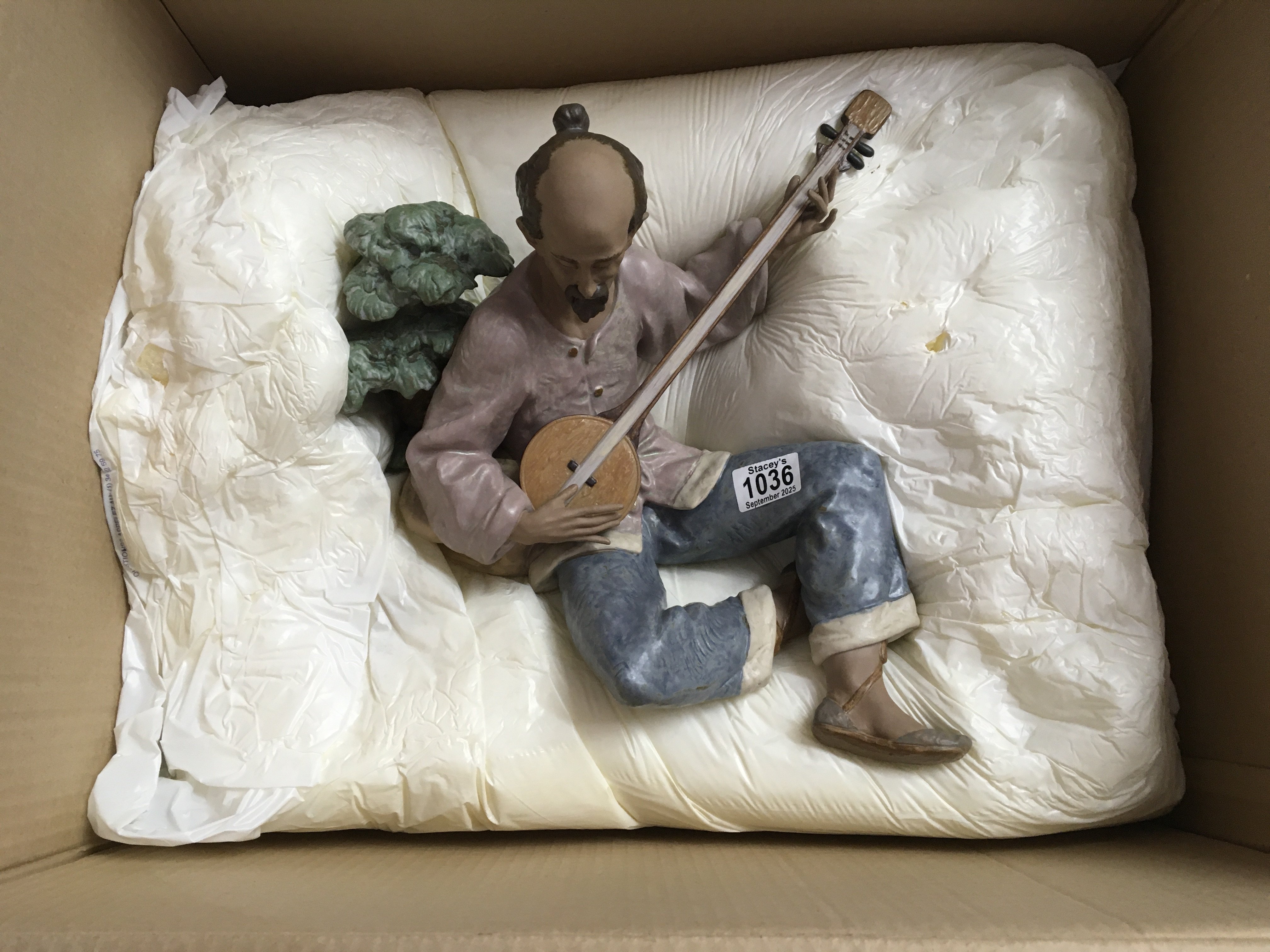 A large boxed Lladro figure of an oriental gentleman playing an instrument. 38cm in height approximately. No obvious damage or restoration