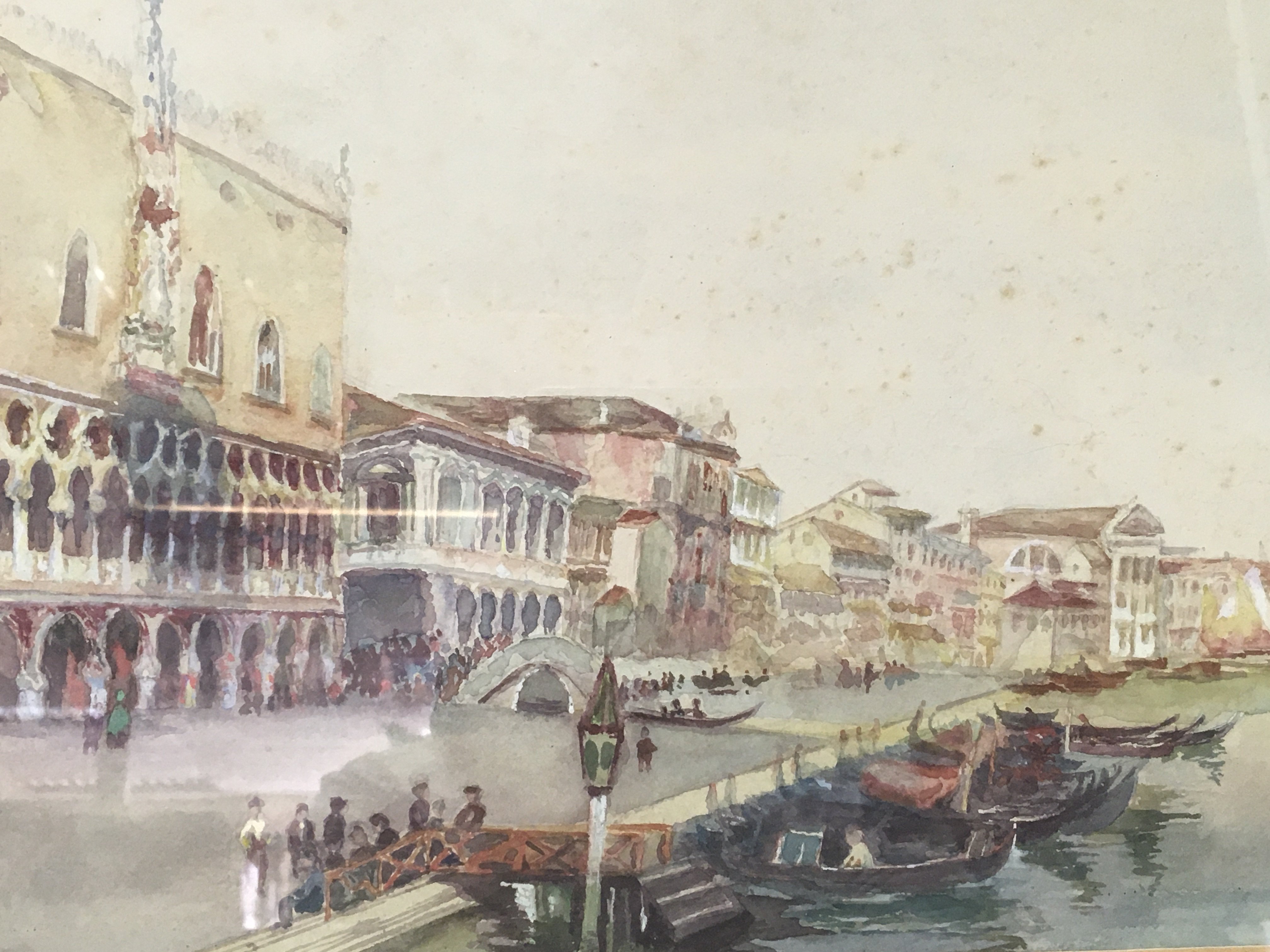 A framed watercolour Venetian scene. With marred gondola and buildings beyound
