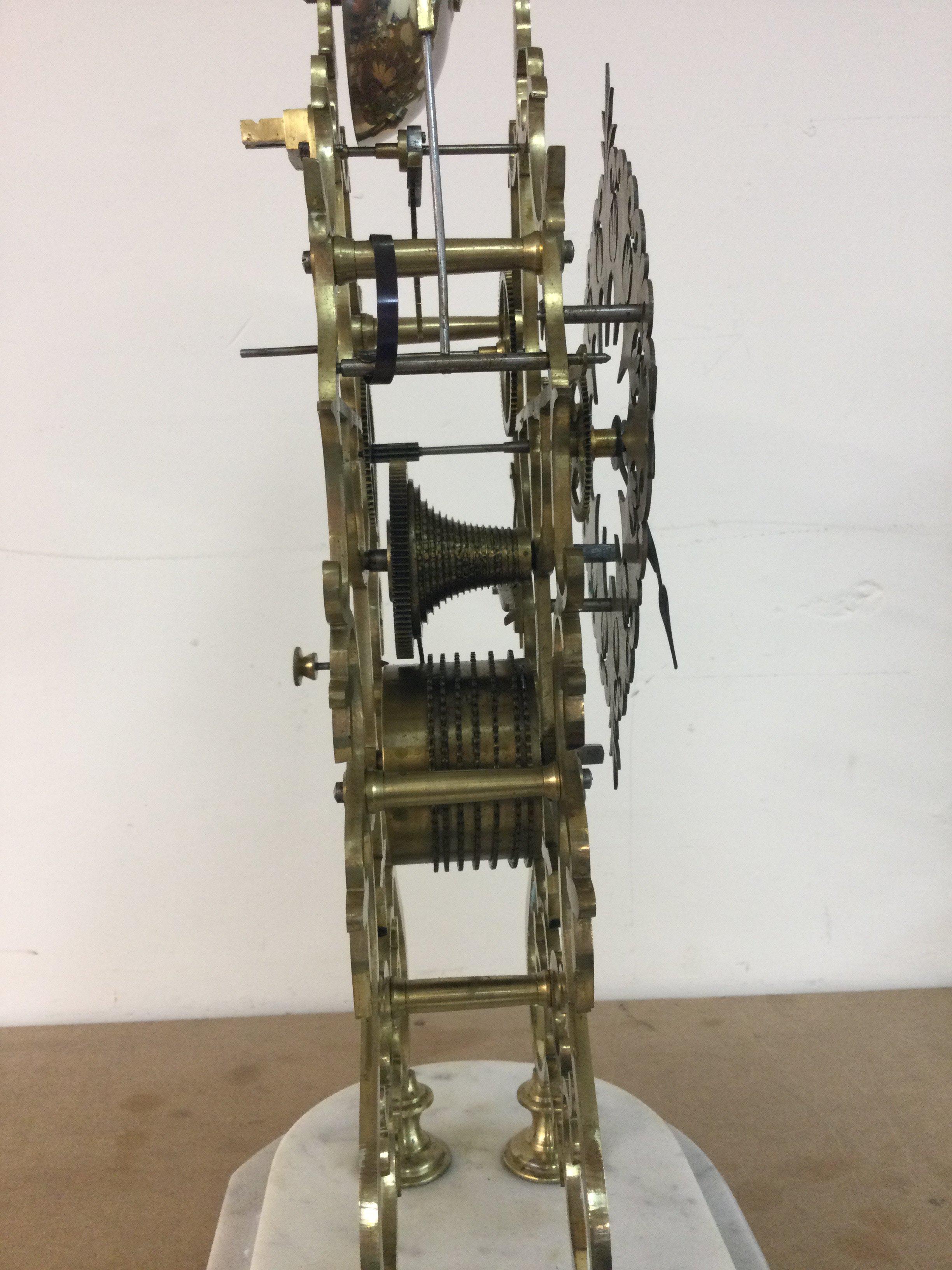 A Victorian brass skeleton clock striking on a bell under glass dome on marble base . 48 cm With key and pendulum.