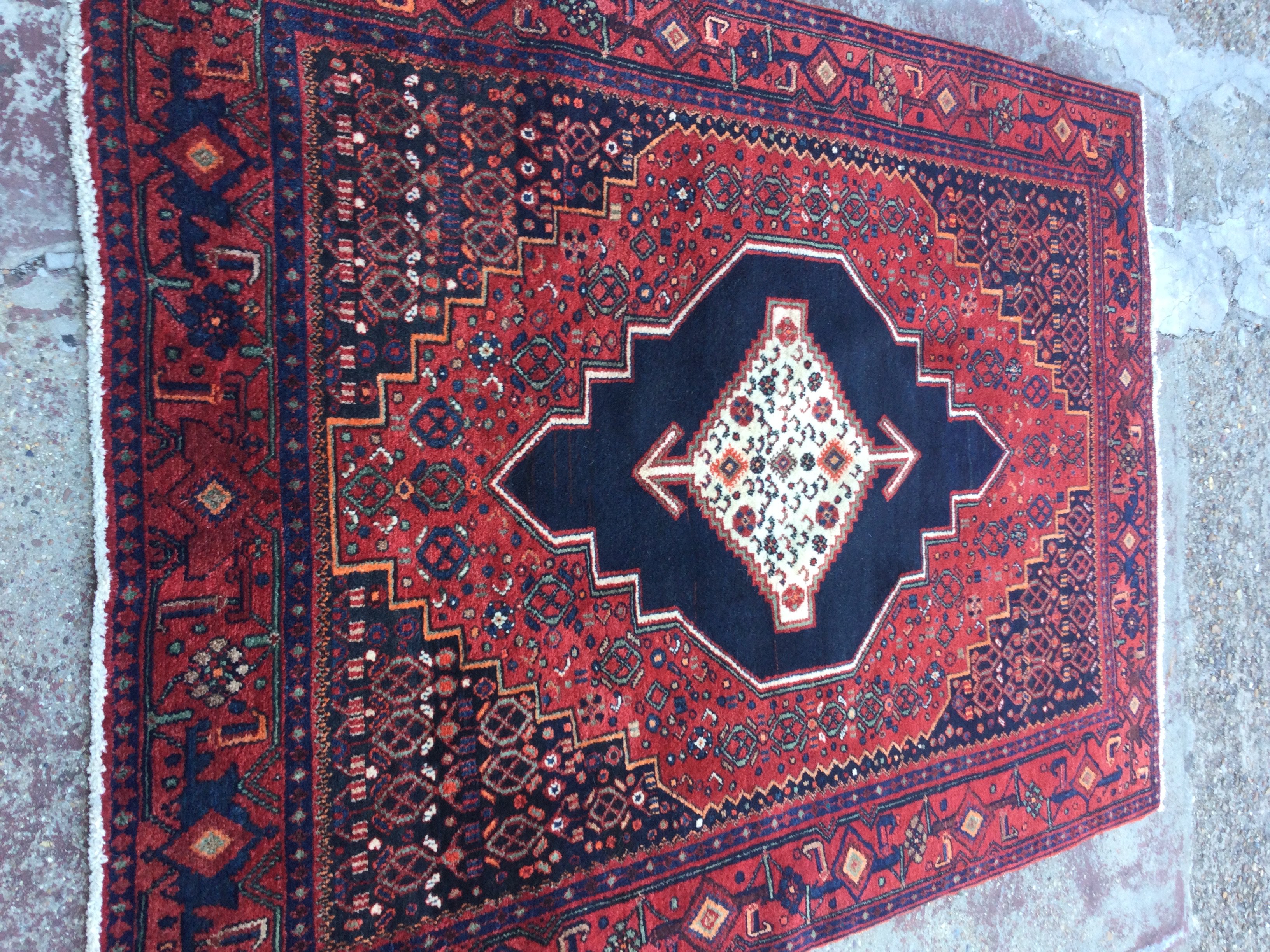 A Persian Senneh rug with geometric an floral design on a red ground .120x 160 cm