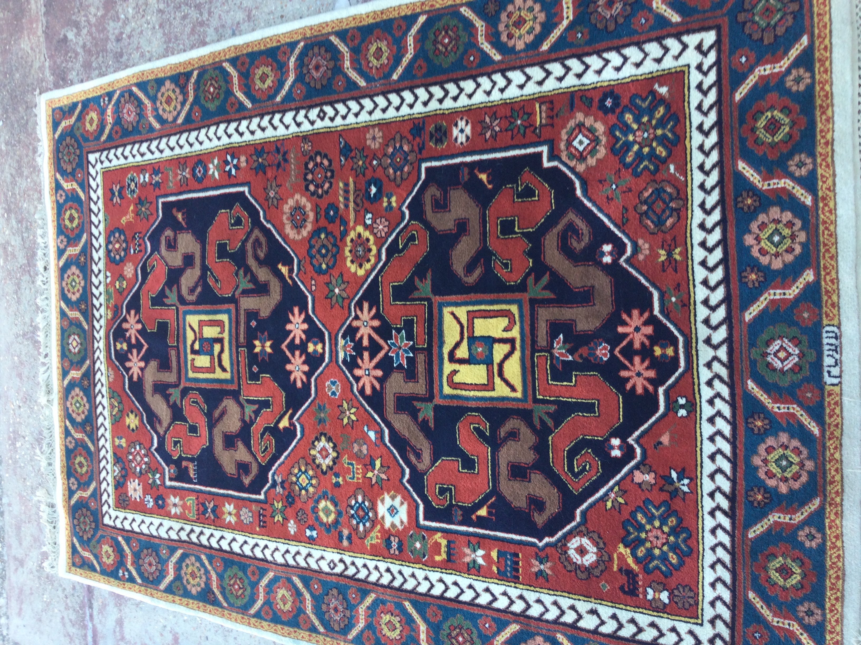 A Kazak Rug with central geometric design and floral boarders . 212 x 142 cm .
