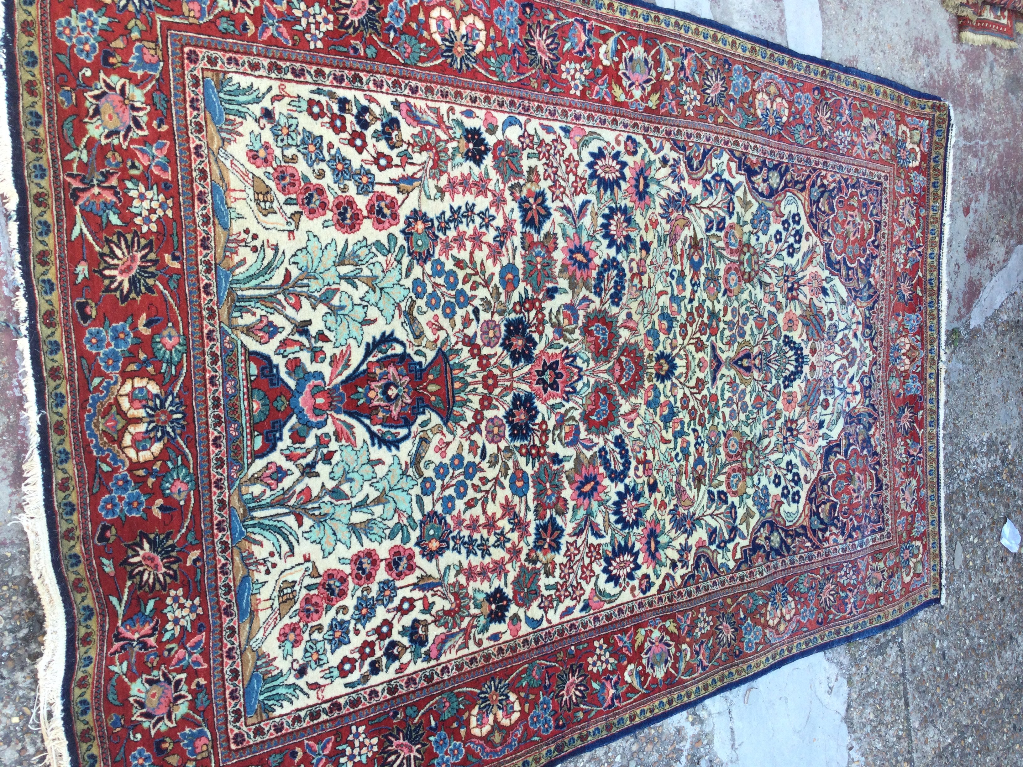 A Persian rug with floral centre and board 210 x 130 cm .