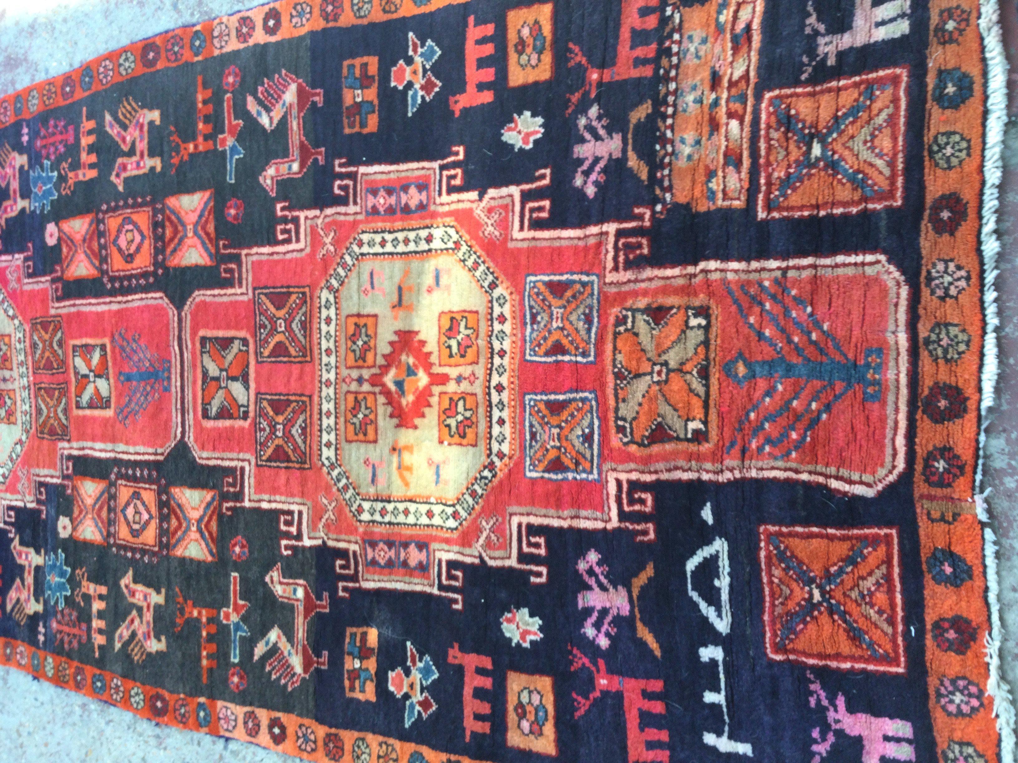 A Persian geometric and animal design runner if a red an blue field. 215 x 118 cm .