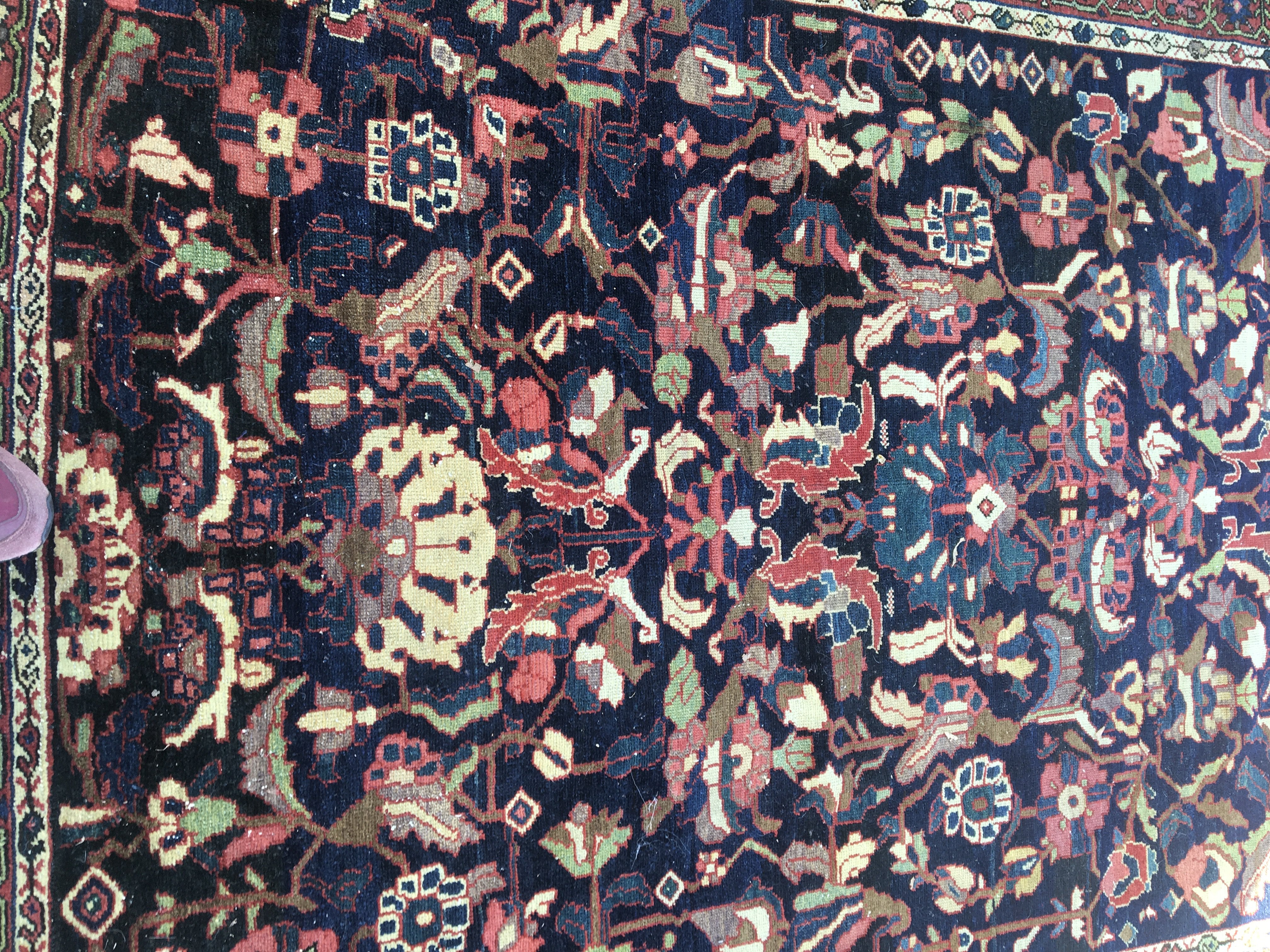 A Persian rug with floral central field and a geometric boarder . 210cm x 138 cm .
