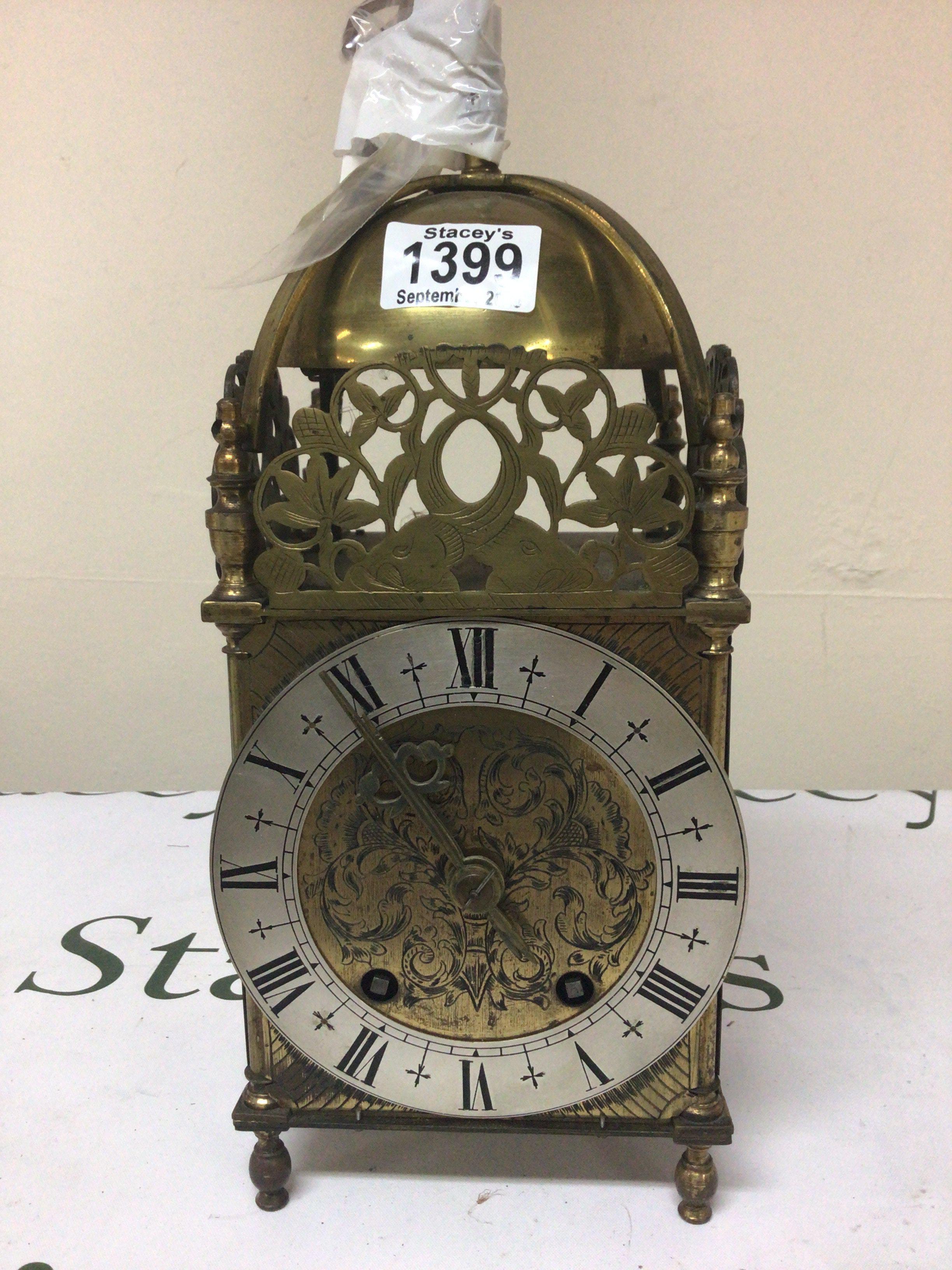 A British brass lantern clock with a silver chapter ring sold with key Height 32cm.