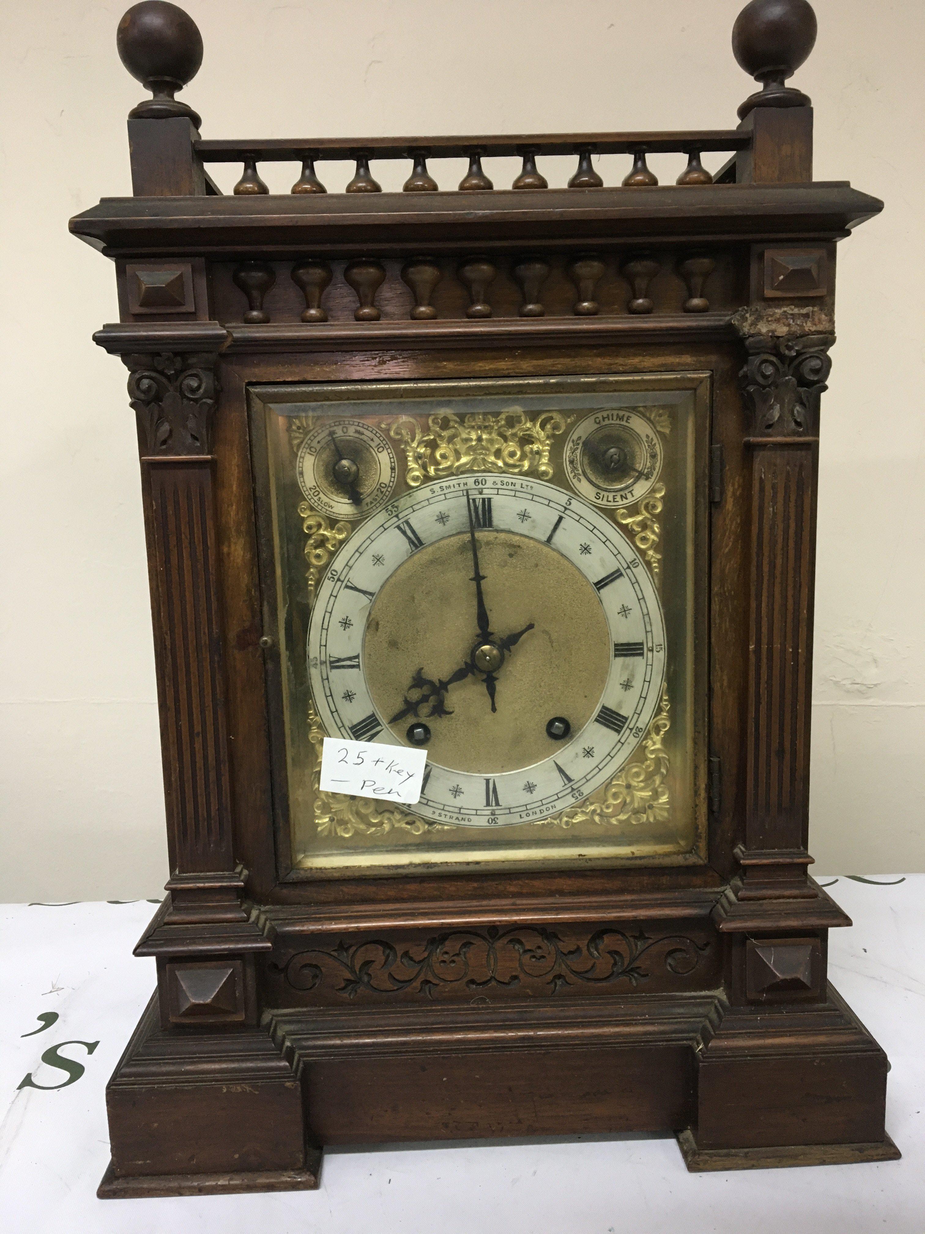 An Edwardian walnut cased mantel clock the case with a gallery above half pilasters silvered chapter ring dial with S Smith & Son Ltd Strand London. With strike silent subsidiary dial key and pendulum 44cm heigh