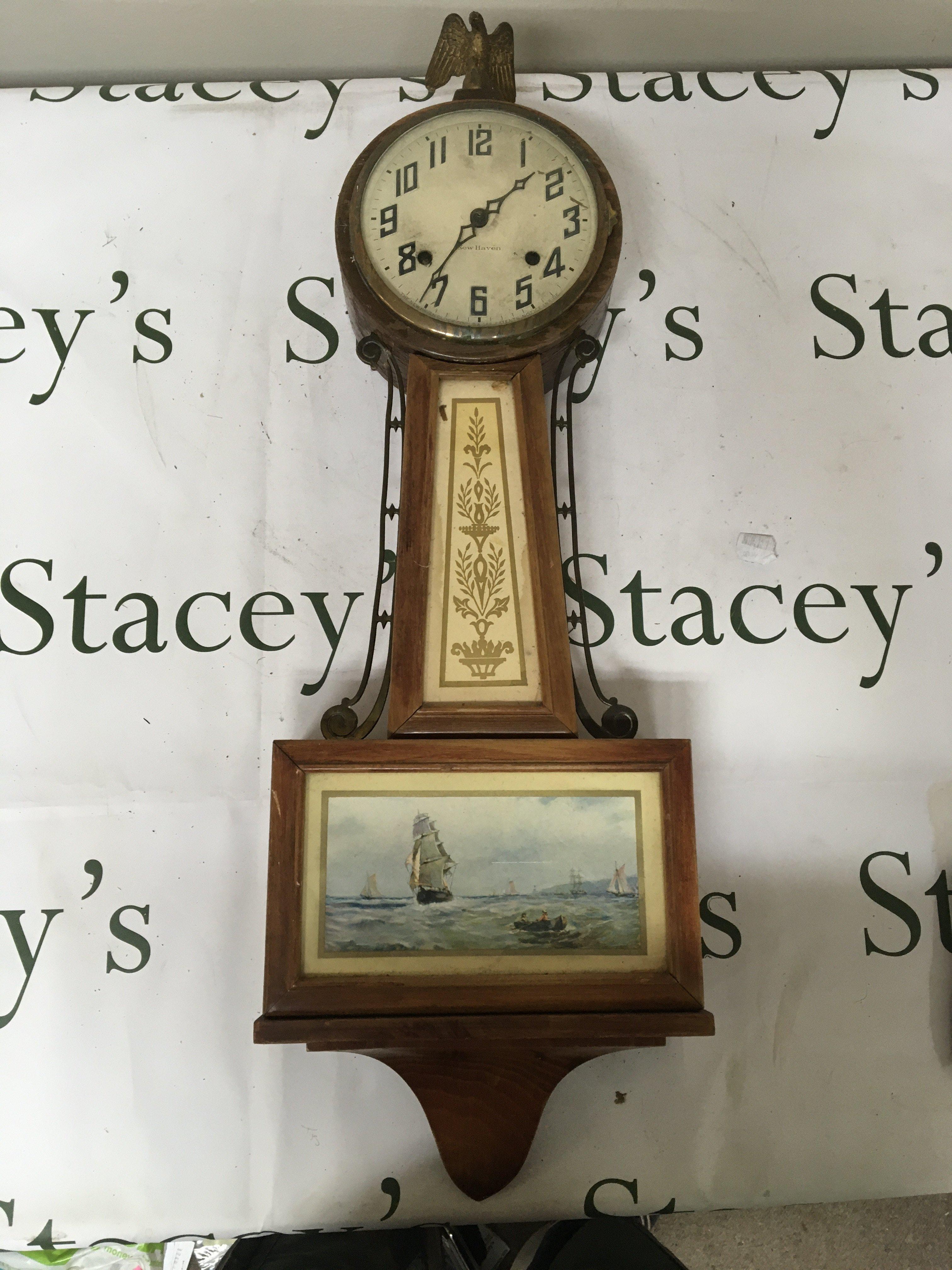 An American wall clock The Newhaven clock the case with brass mounts inset with a marine view. the case surmounted with an Eagle. Length 75cm