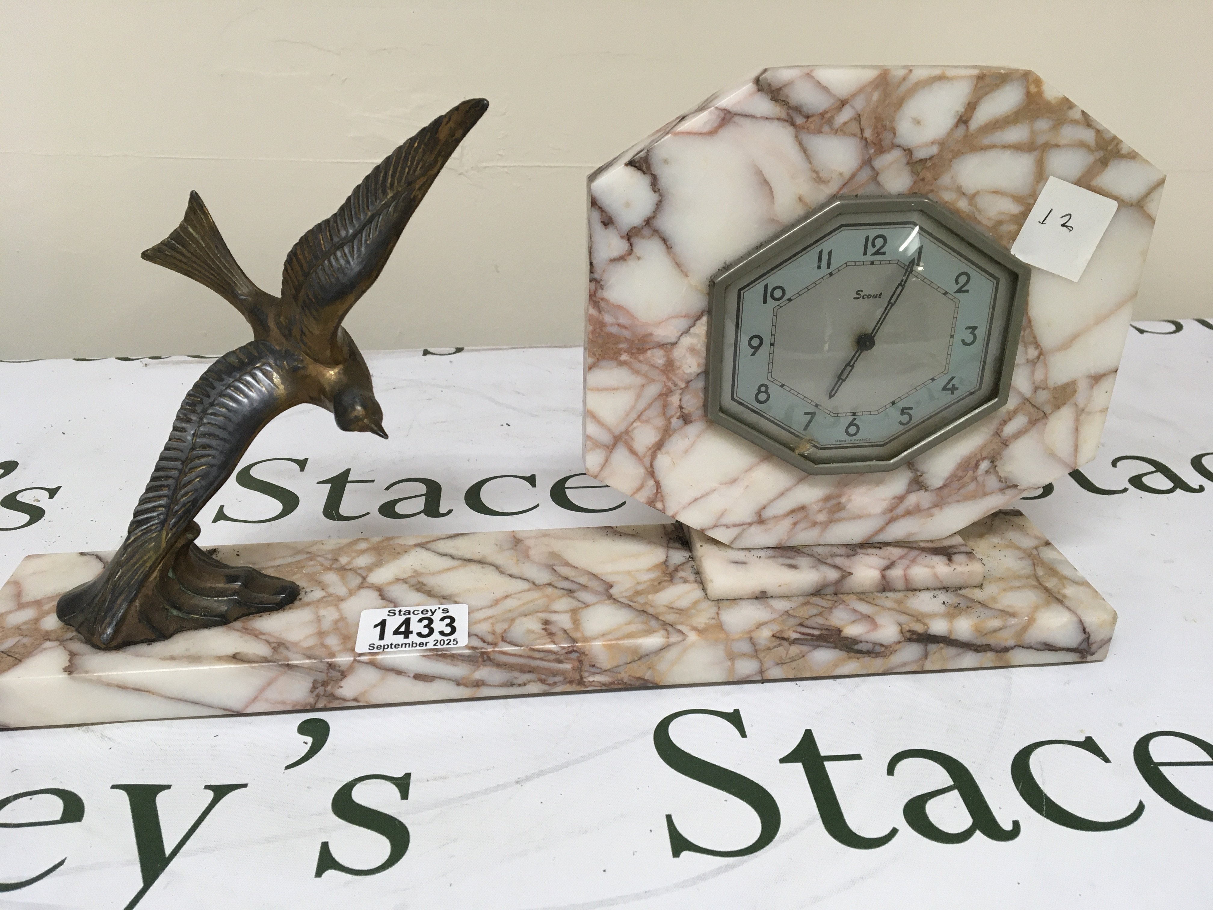 An Art Deco French Marble mantel clock surmounted with a flying bird. Length 41cm